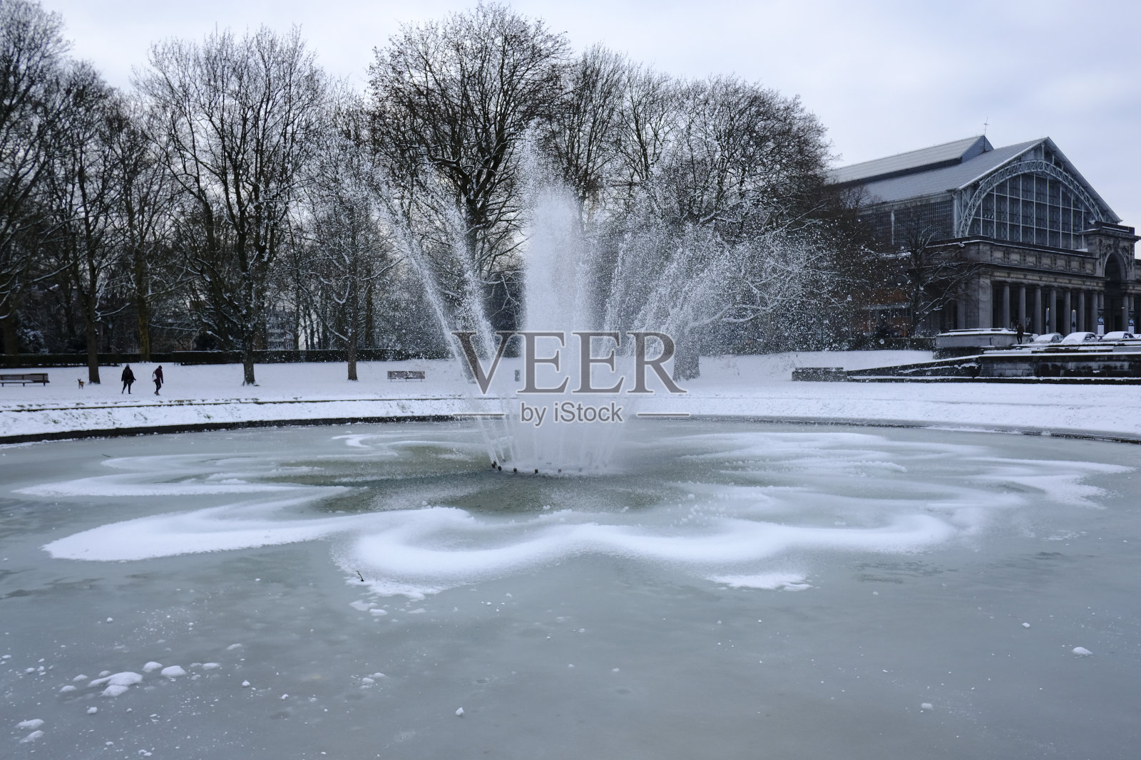 人们在大雪纷飞中走过白雪覆盖的街道。照片摄影图片