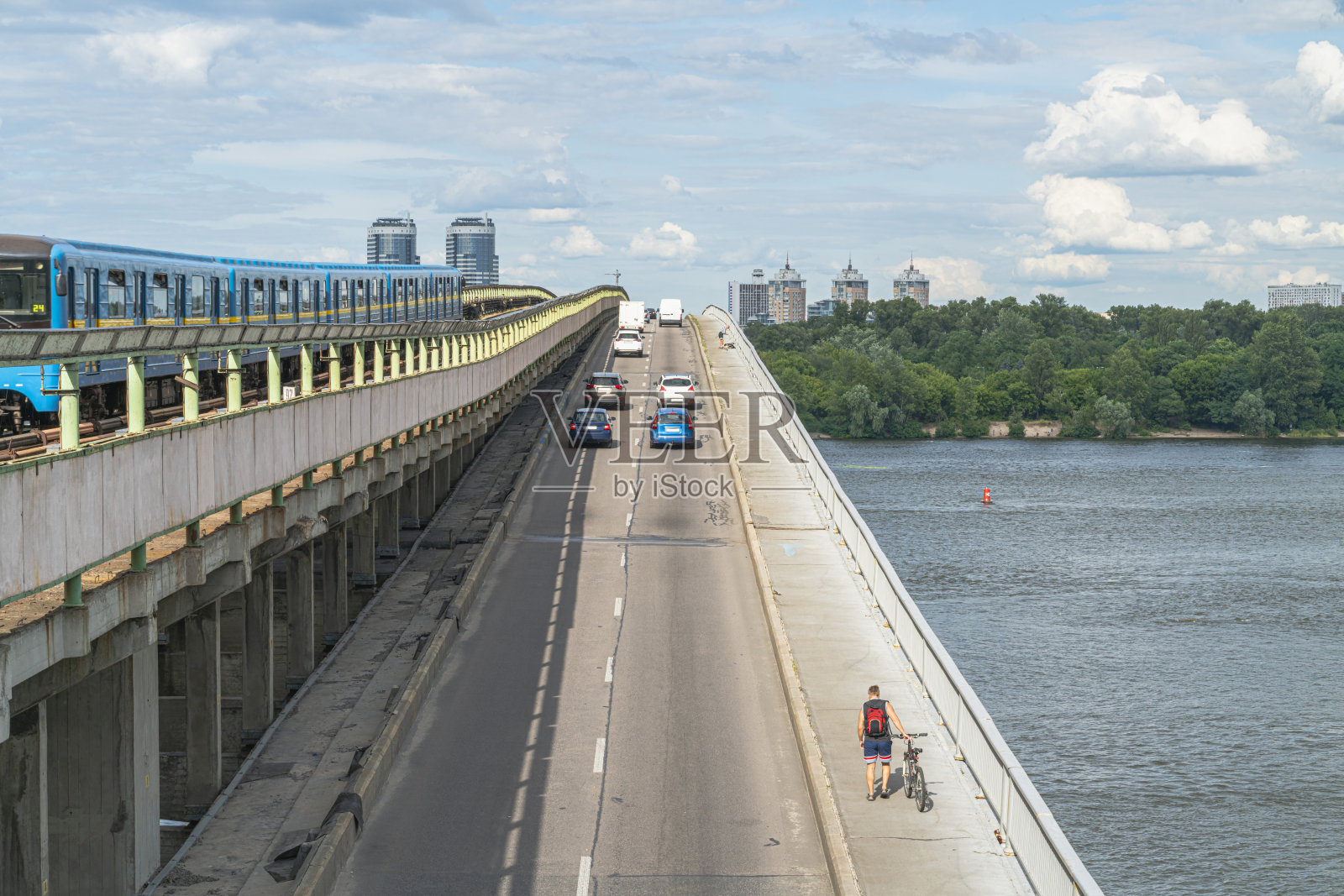 基辅/乌克兰:基辅的地铁桥在夏季横跨第聂伯河，有各种各样的交通工具，从生态到环境污染。照片摄影图片