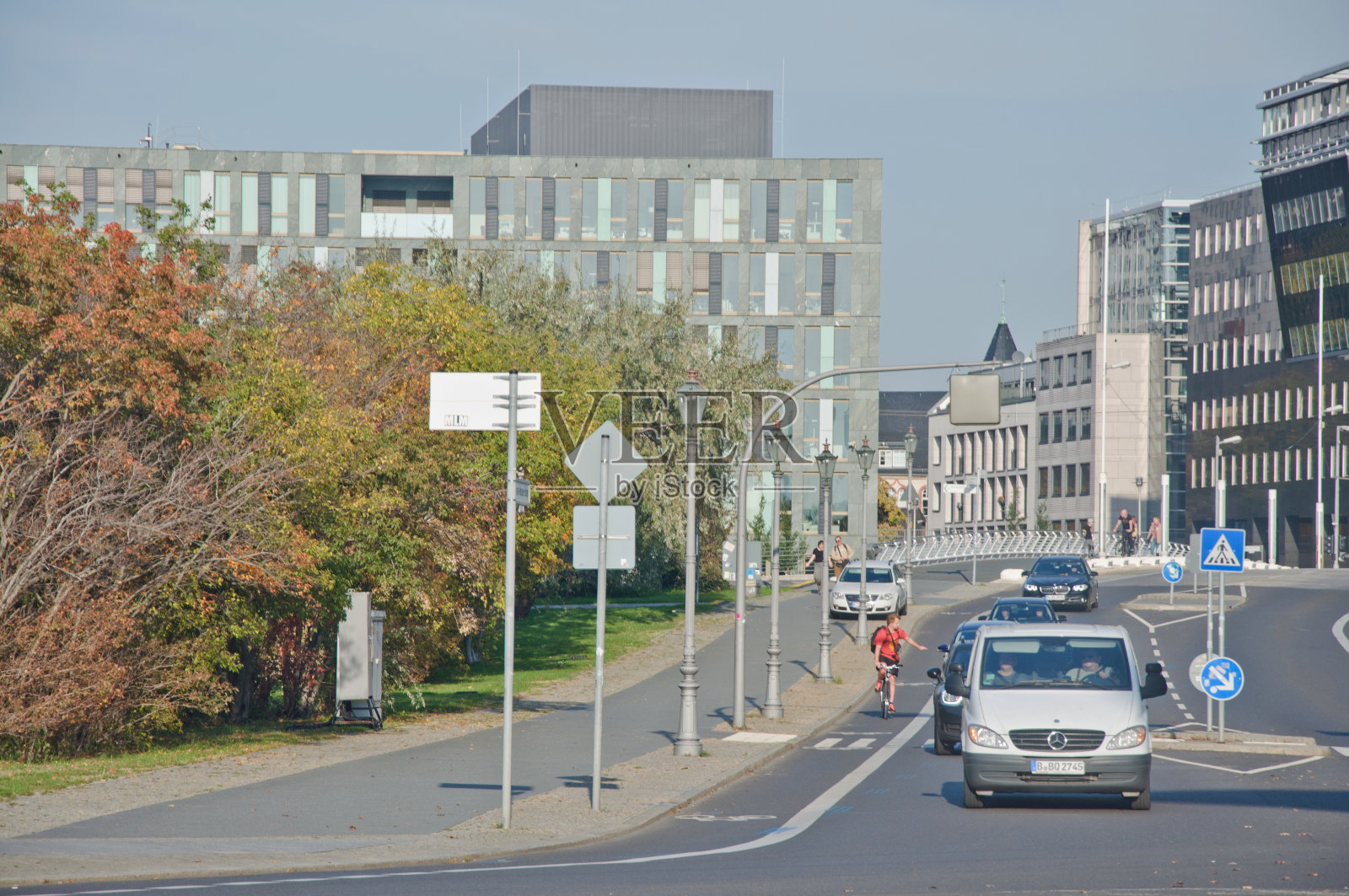在德国柏林的一个十字路口，开车的人(包括一名骑自行车的人)照片摄影图片