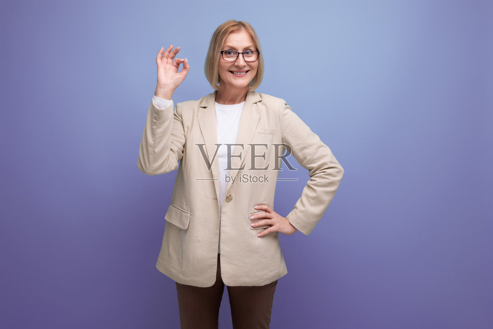 精力充沛的成熟女人在明亮的工作室背景与复制空间的时尚夹克照片摄影图片