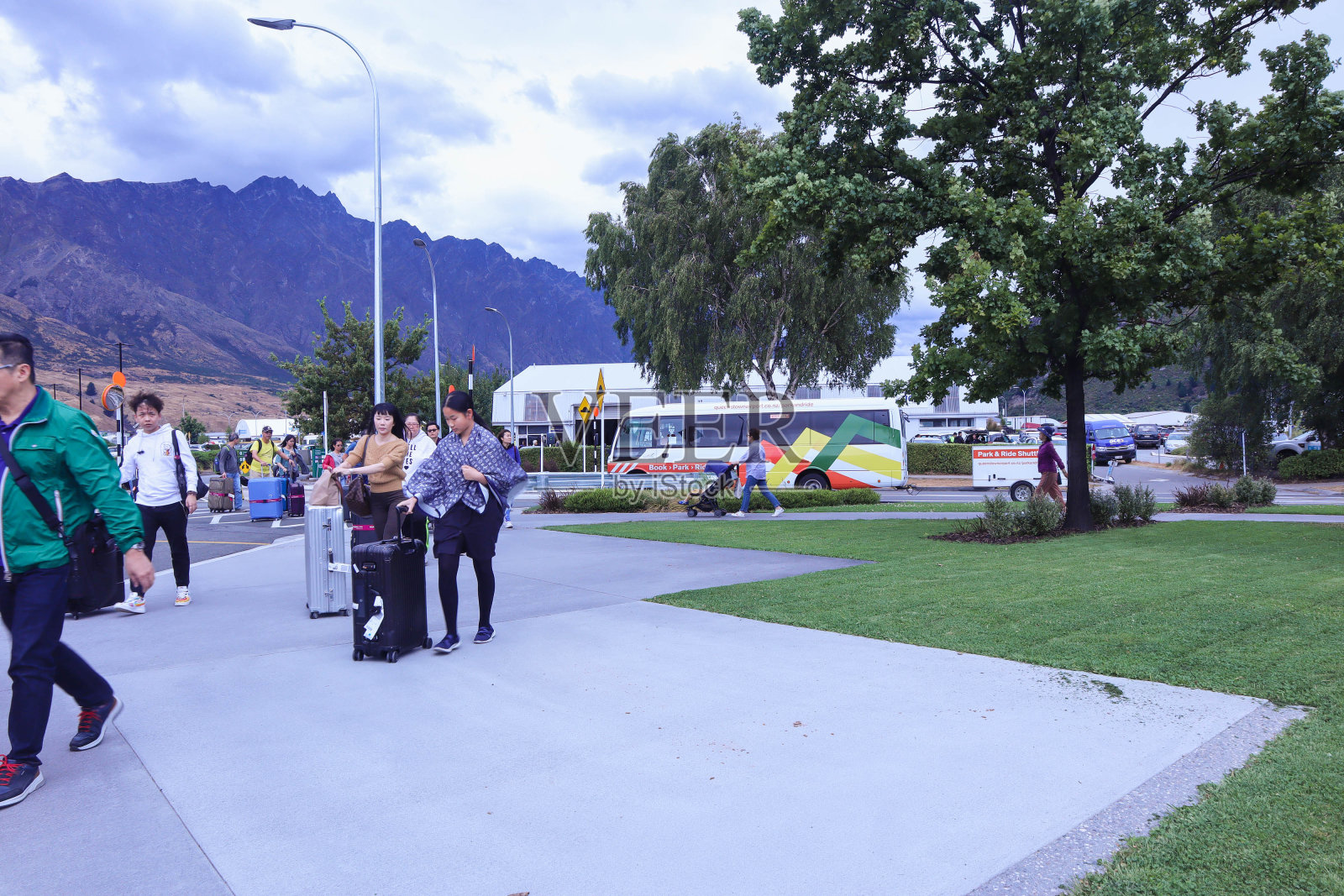 在皇后镇机场登上巴士的亚洲旅游团照片摄影图片