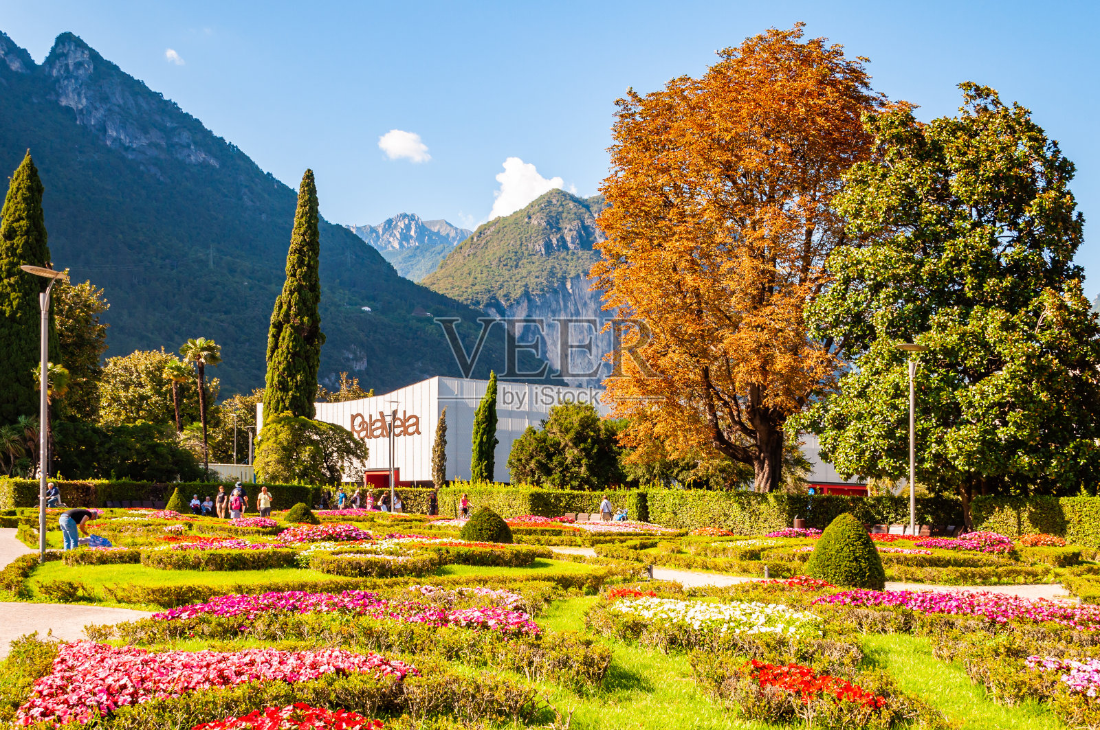 人们在加尔达湖长廊漫步,背景是帕拉韦拉会议中心照片摄影图片