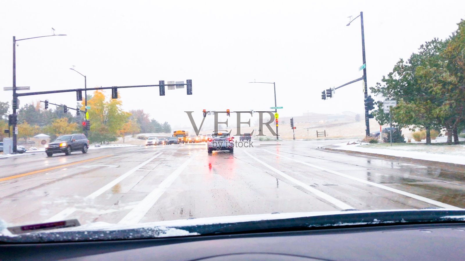 在第一场暴风雪期间在典型的北美郊区开车照片摄影图片