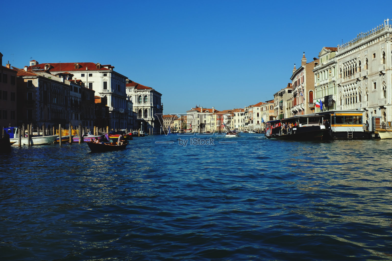 从平底船上俯瞰威尼斯大运河的低角度秋日阳光明媚。照片摄影图片