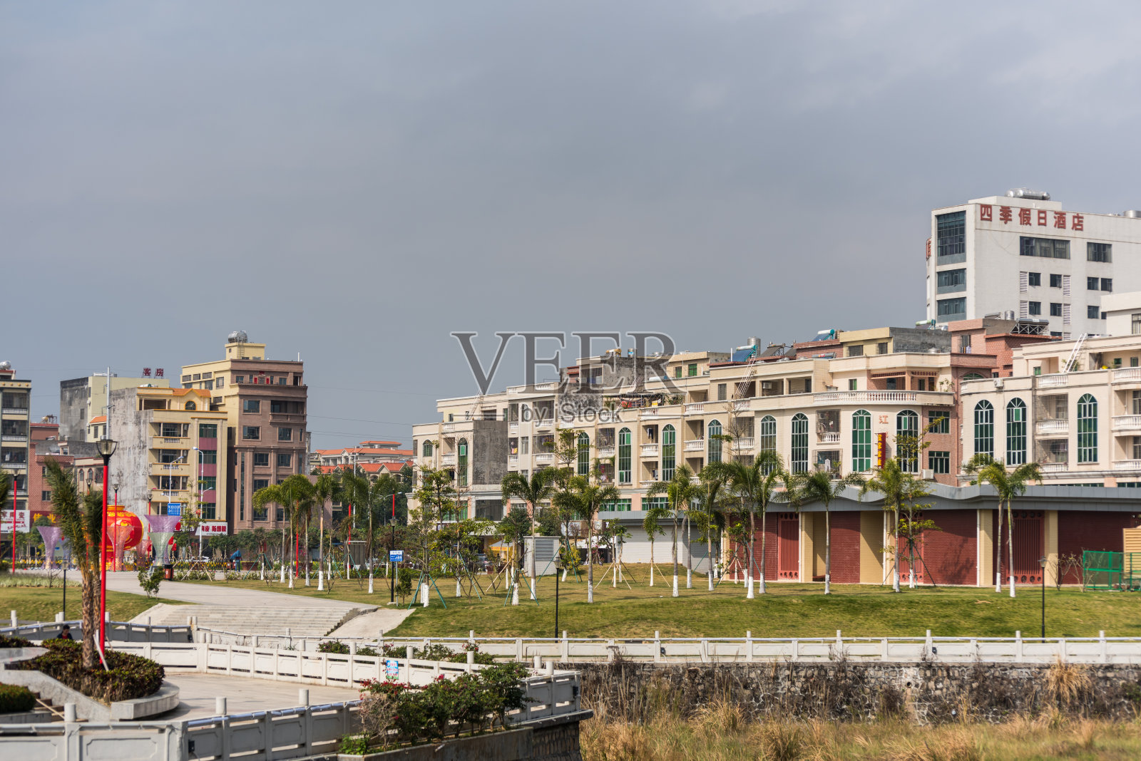 中国阳溪镇公园里的住宅建筑和棕榈树。照片摄影图片