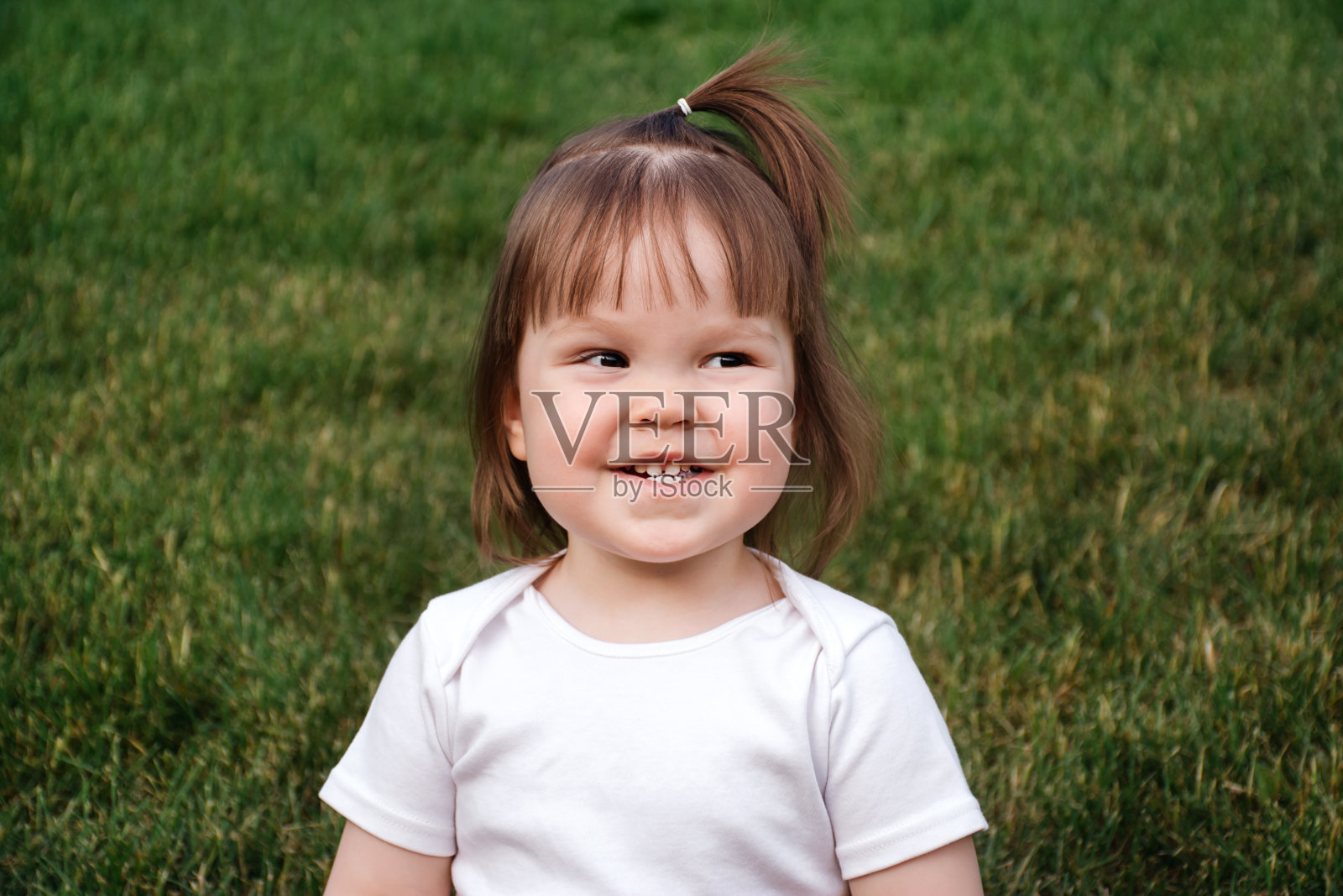 一个扎着马尾辫的小女孩微笑着，露出了她的第一颗牙齿。的生活方式。特写镜头。副本的空间。照片摄影图片