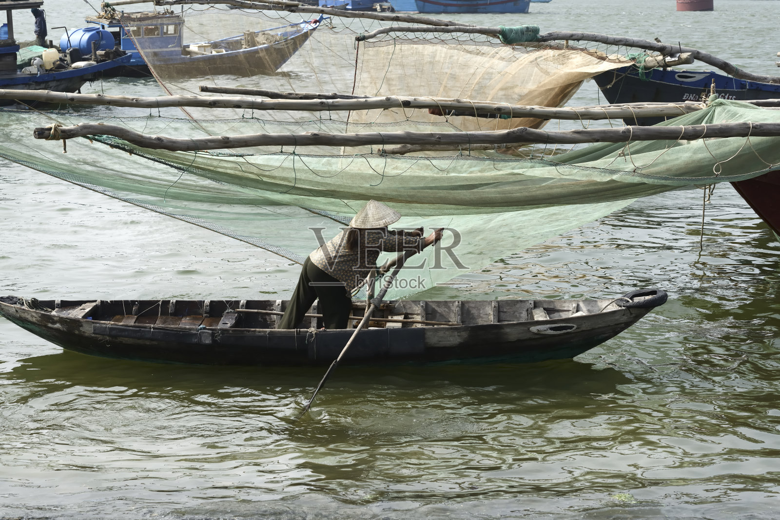 越南妇女划着大渔网照片摄影图片