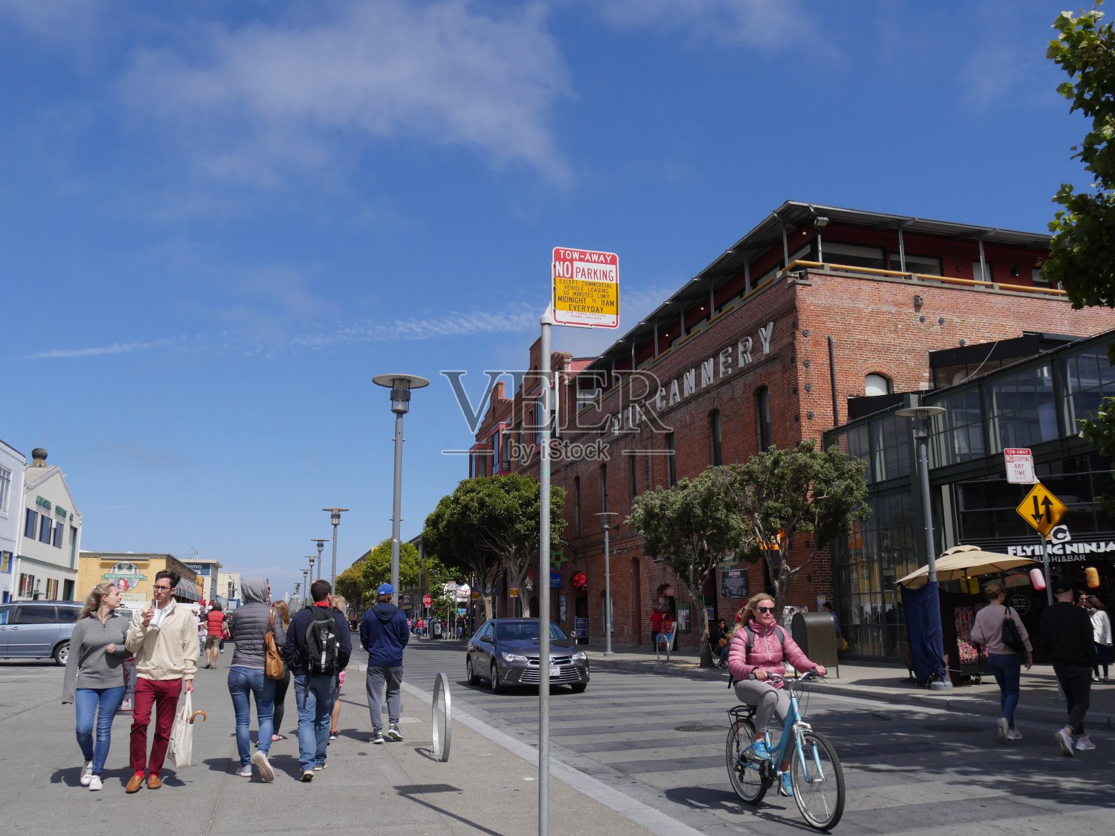 渔人码头的街景，人们步行和骑自行车。照片摄影图片