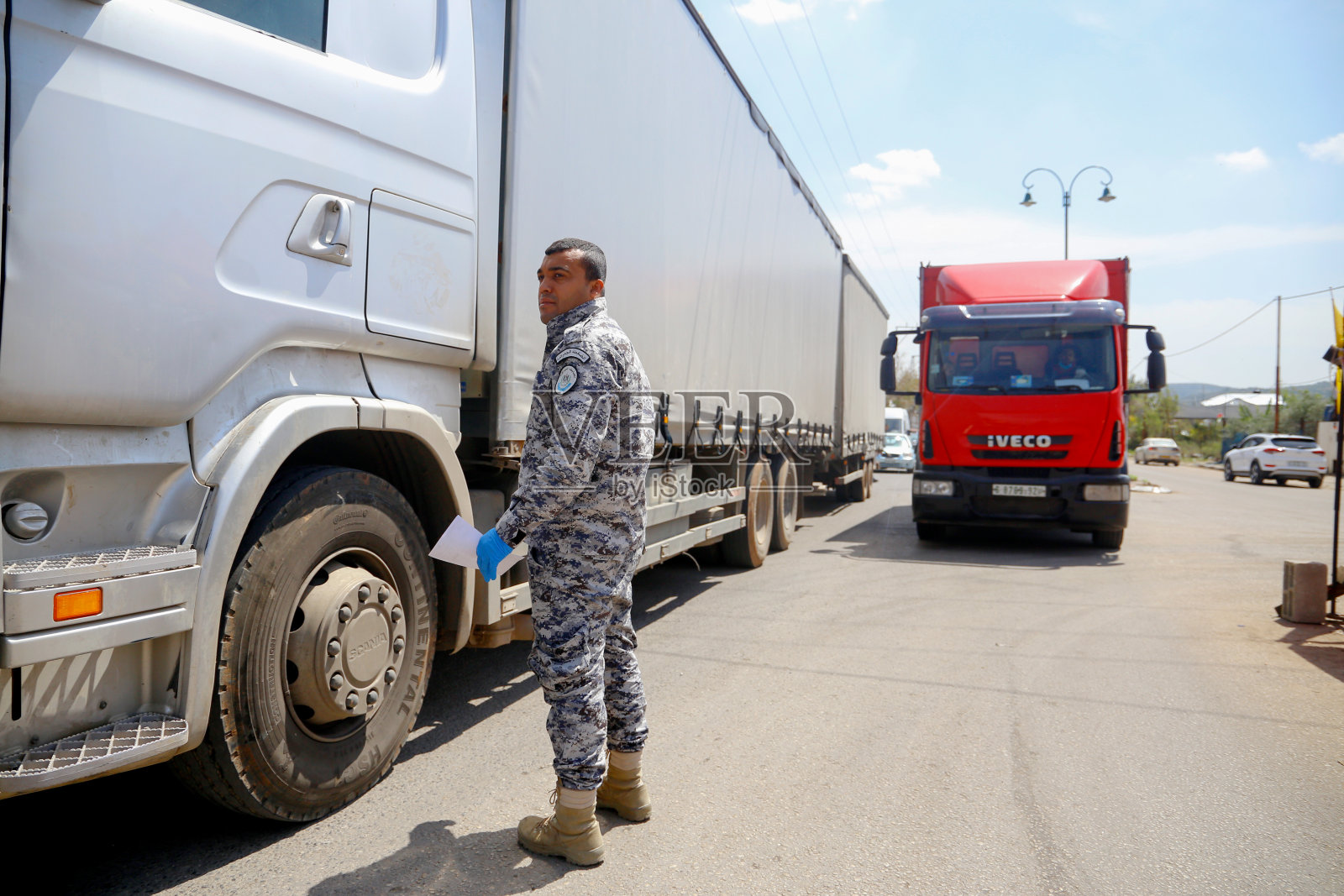 士兵在检查站站岗，检查司机的证件照片摄影图片