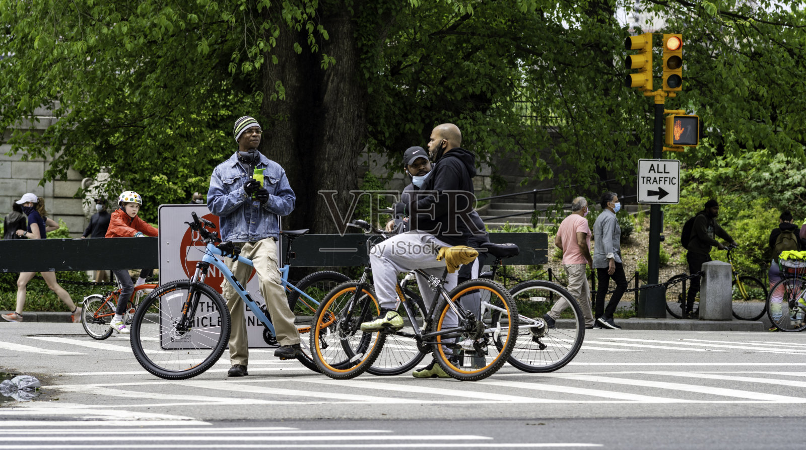 新冠肺炎期间，三个骑自行车的人一起在中央公园休息照片摄影图片