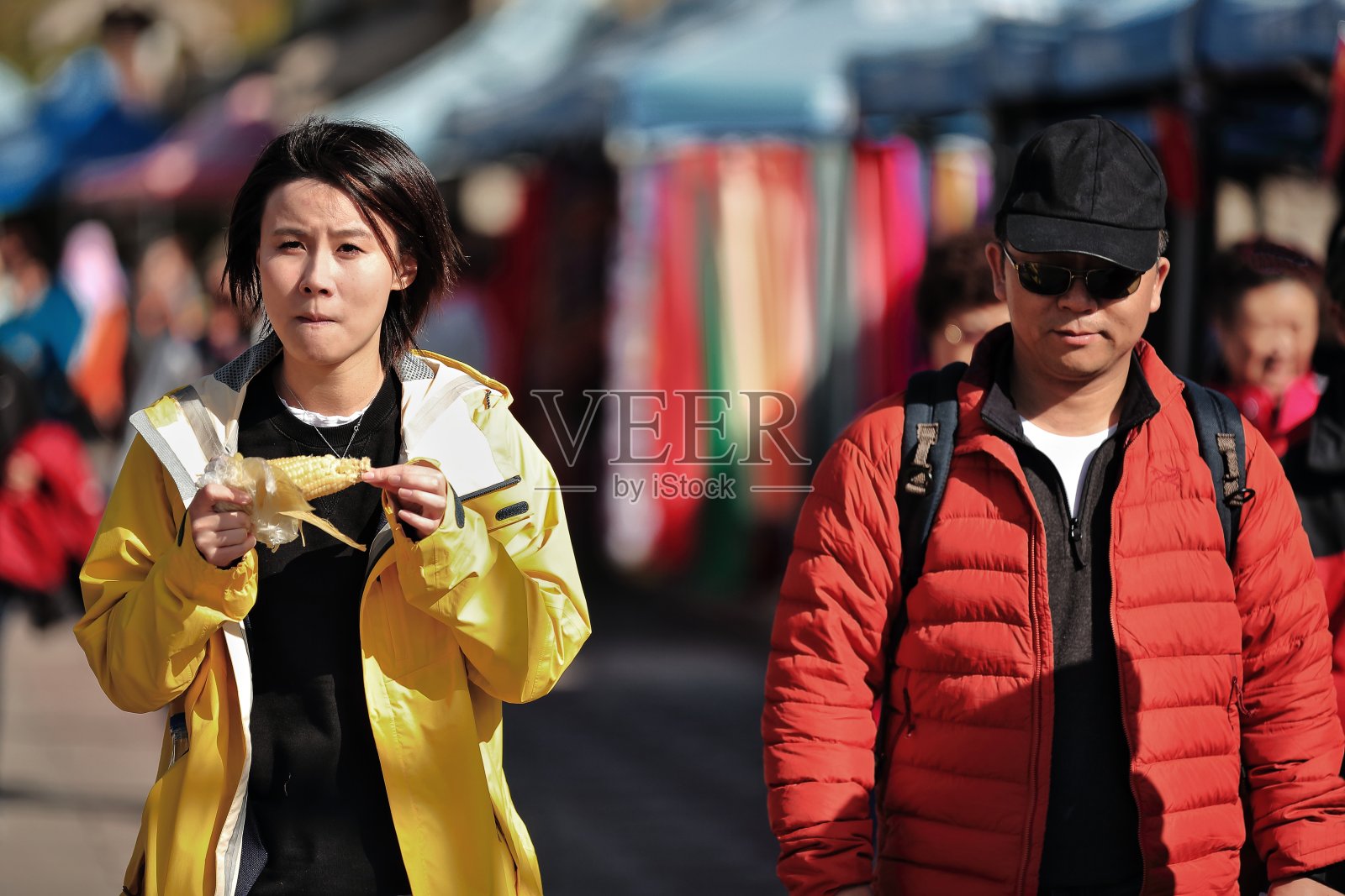 在附近街边小摊上吃玉米棒子的中国年轻人。中国-甘肃嘉峪关城市- 0804照片摄影图片