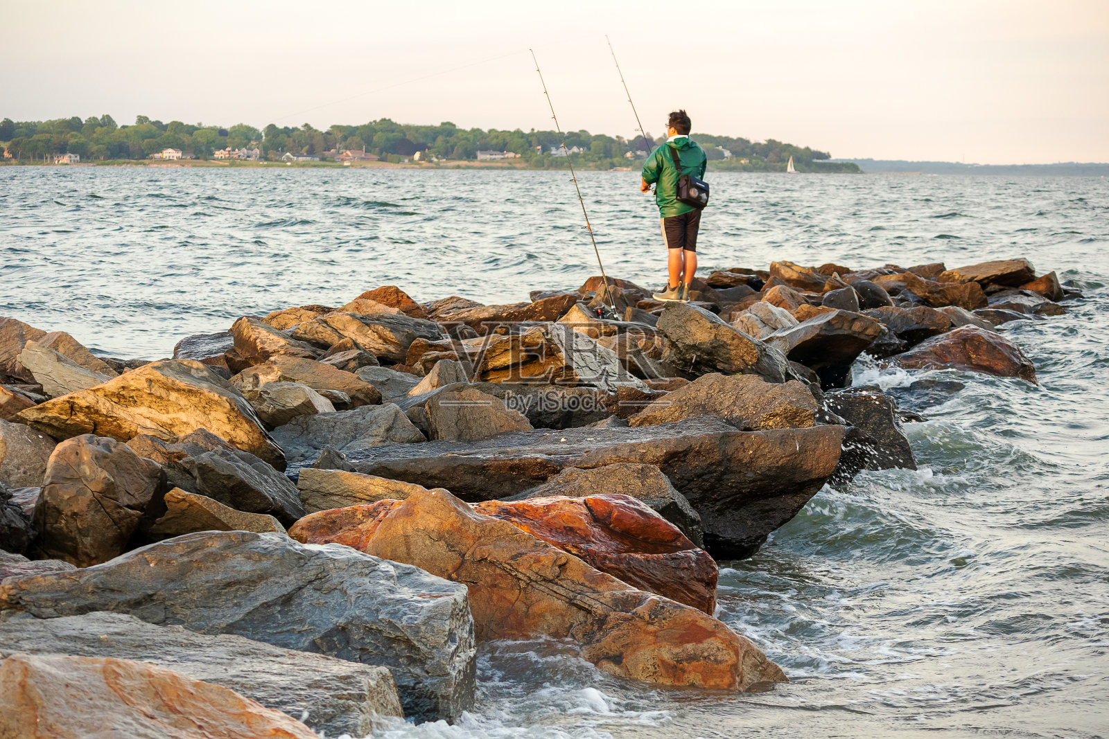 日落时分，罗德岛东格林威治的岩石海滩上的费舍尔照片摄影图片