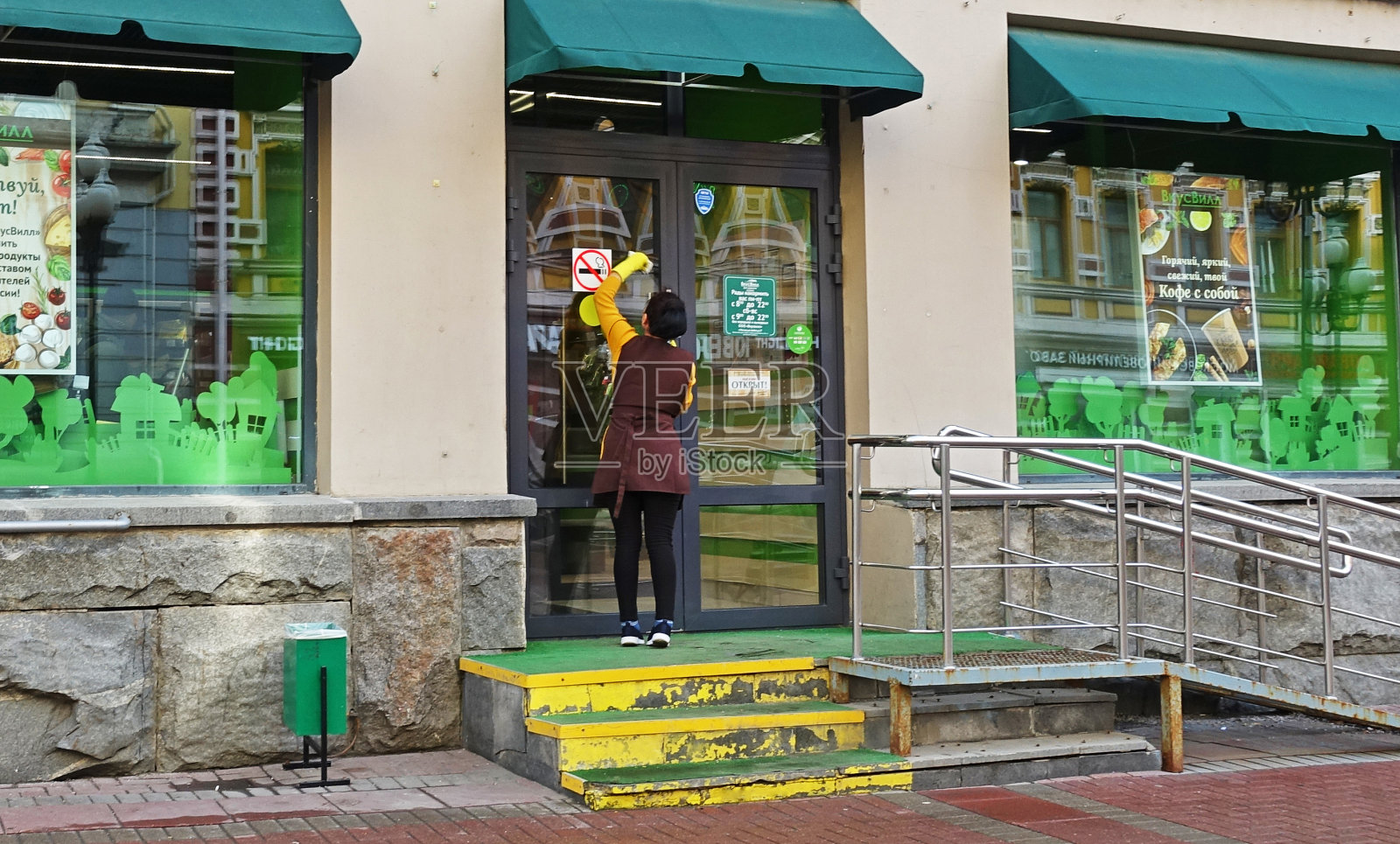 清晨,一名女工在阿尔巴特清洗一家玻璃商店的橱窗照片摄影图片