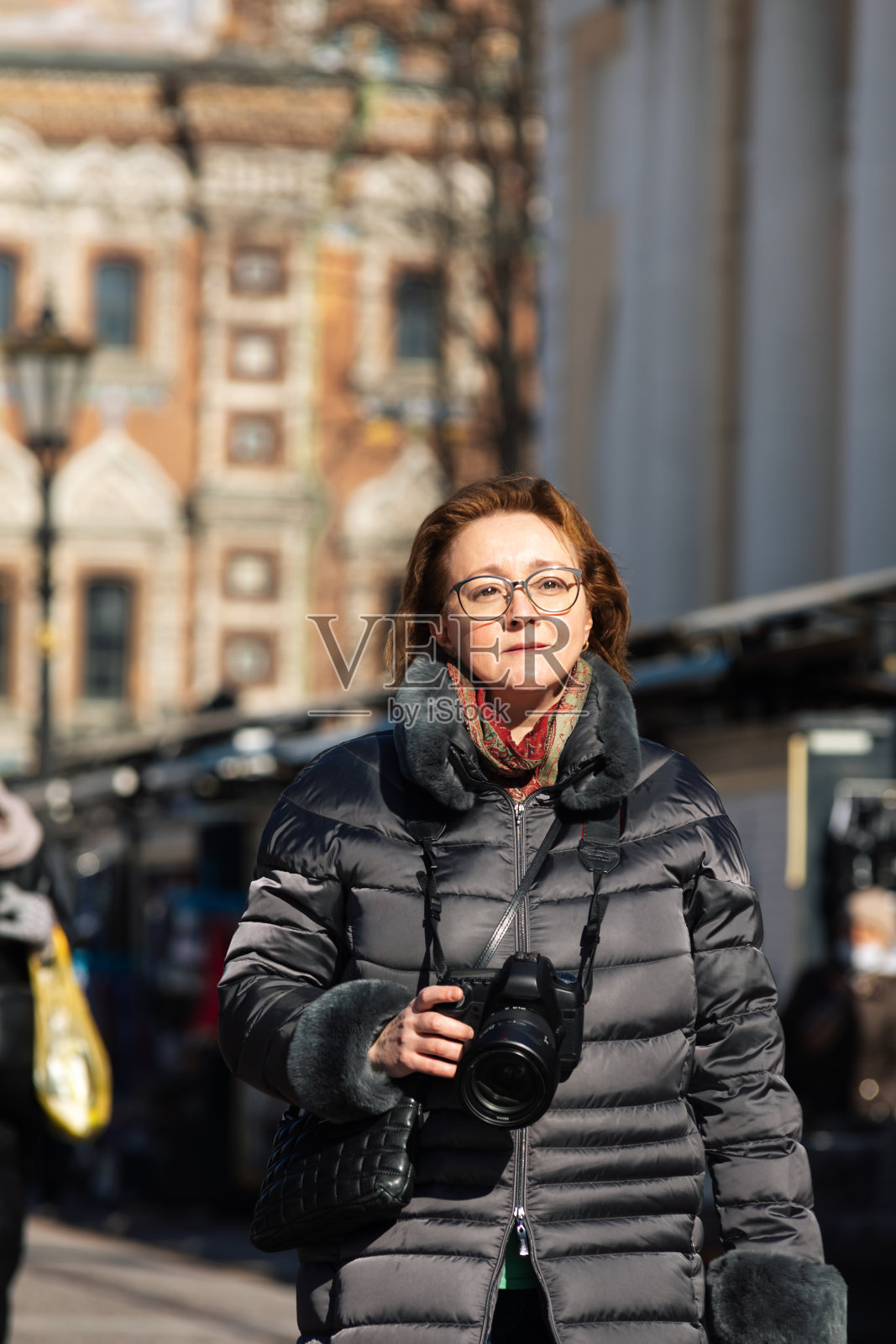 度假的快乐女人在城市的街道上用相机拍照照片摄影图片