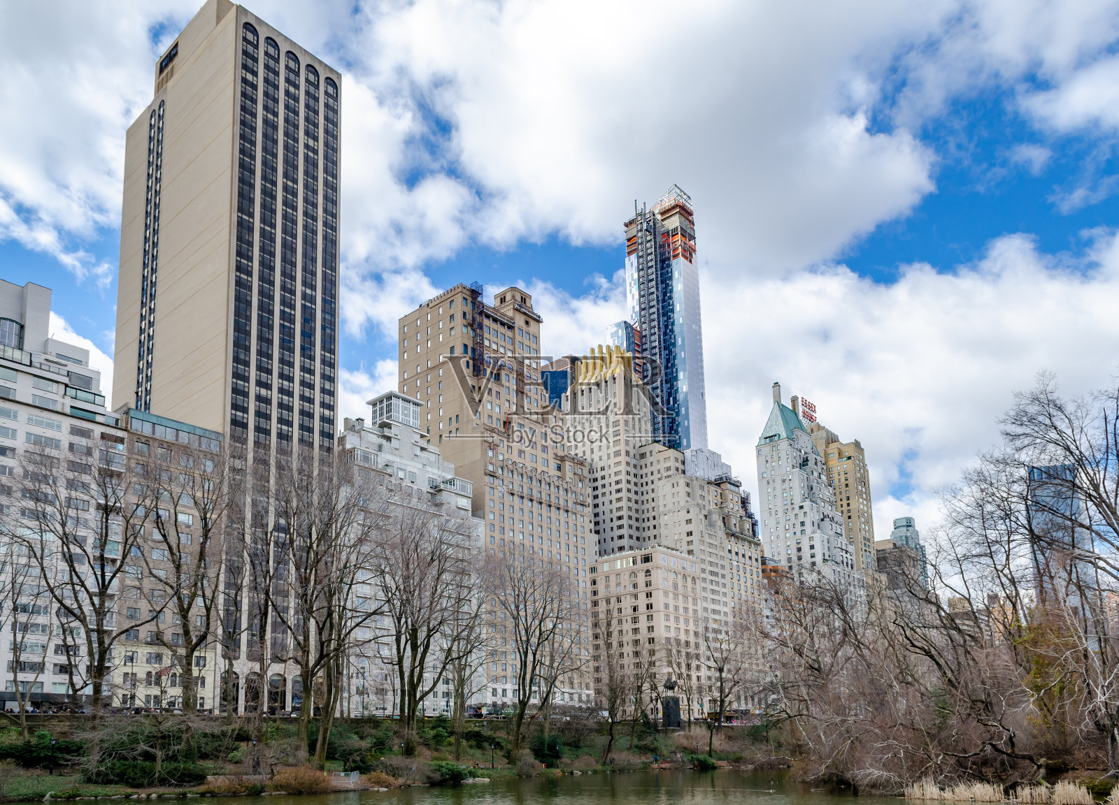 曼哈顿的天际线与埃塞克斯住宅摩天大楼，在最前面的中央公园湖的池塘照片摄影图片