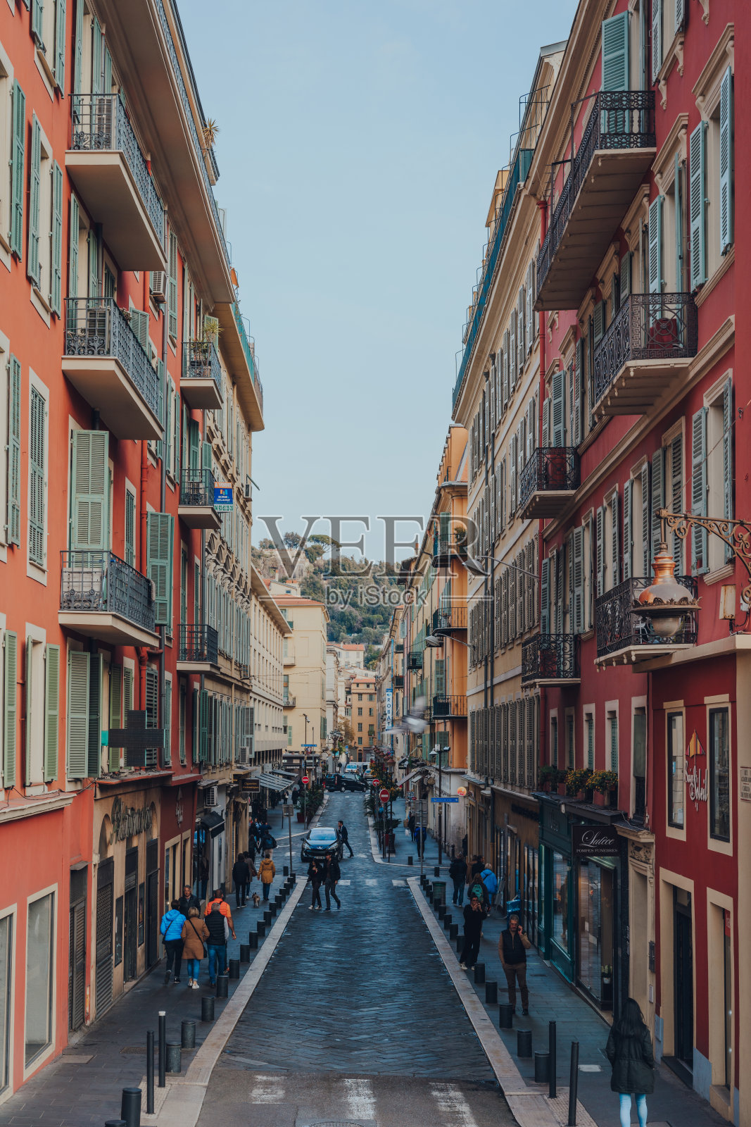 法国尼斯典型的街道两旁排列着传统的彩色建筑。照片摄影图片