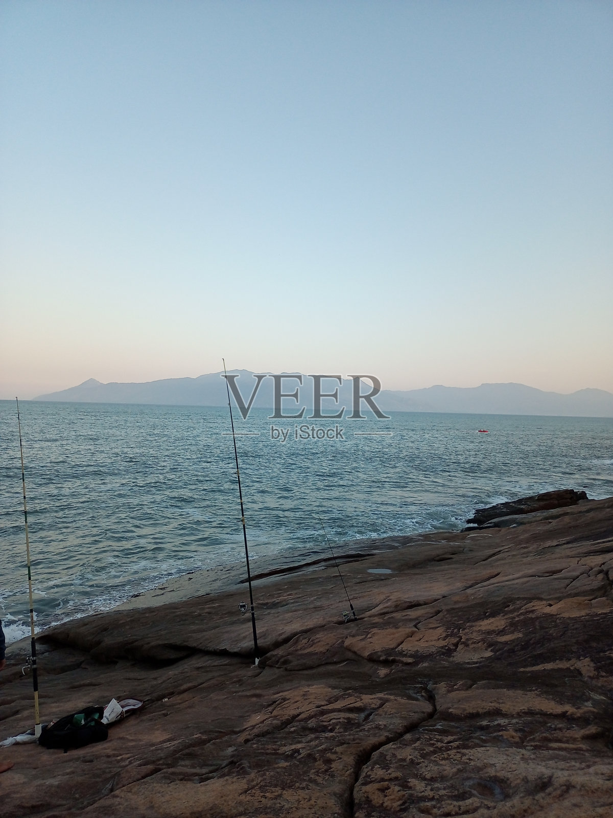 下午在海边的岩石上钓鱼照片摄影图片