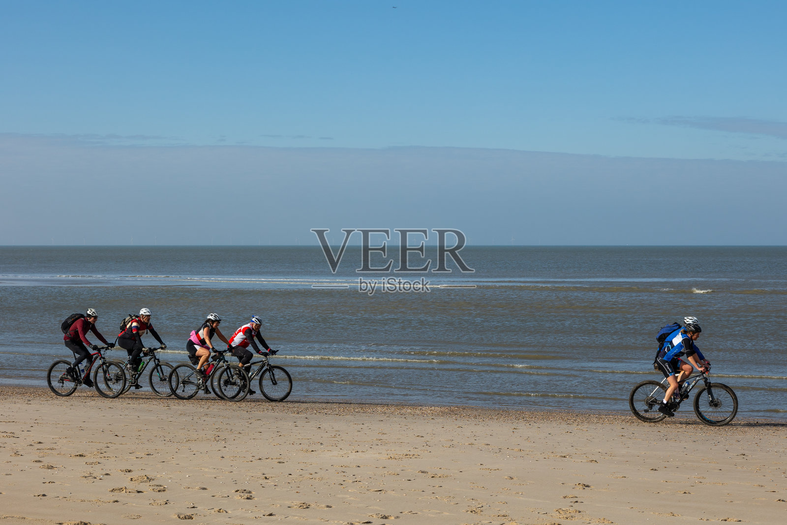 在荷兰Egmond aan Zee附近的海滩上骑山地自行车的人照片摄影图片