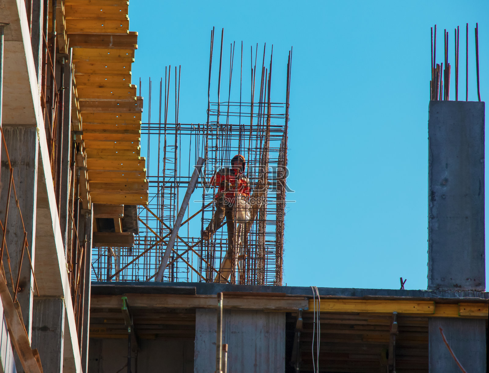 一名工人正在为住宅建筑的现代金属混凝土结构准备模板。照片摄影图片