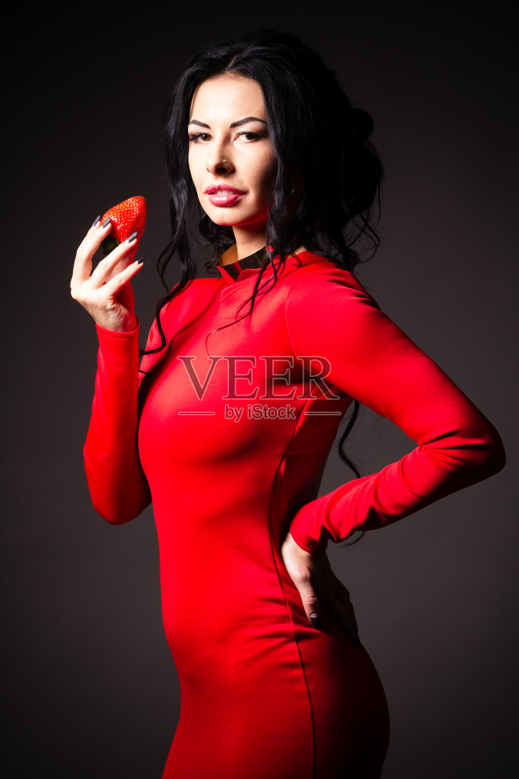 肖像的黑发美女与蜂蜜滴草莓。照片摄影图片