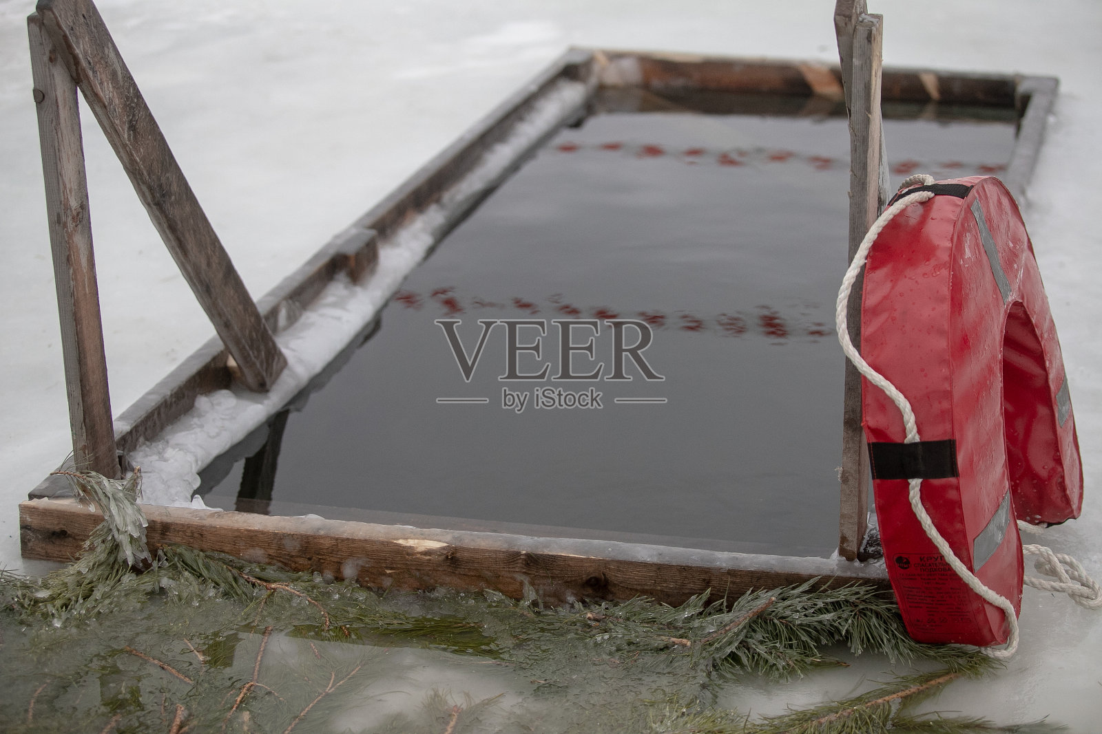 受洗、沐浴在冬季冰洞中，在结冰的河上用冰十字架点缀美丽的冬季景观照片摄影图片