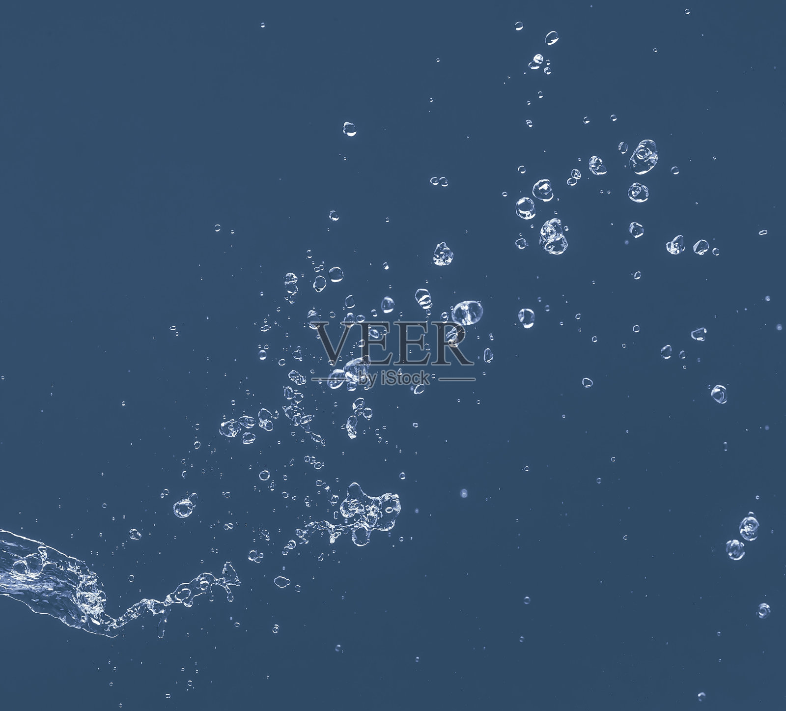 蓝色背景上的水花。照片摄影图片