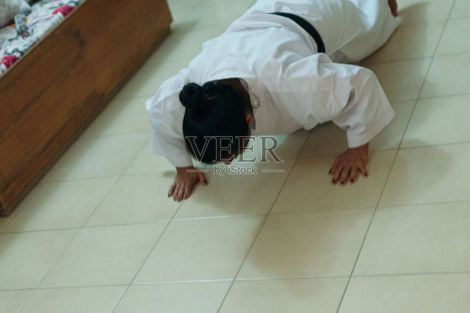 女子在空手道训练前穿着和服热身。他们正在做手臂伸展运动照片摄影图片