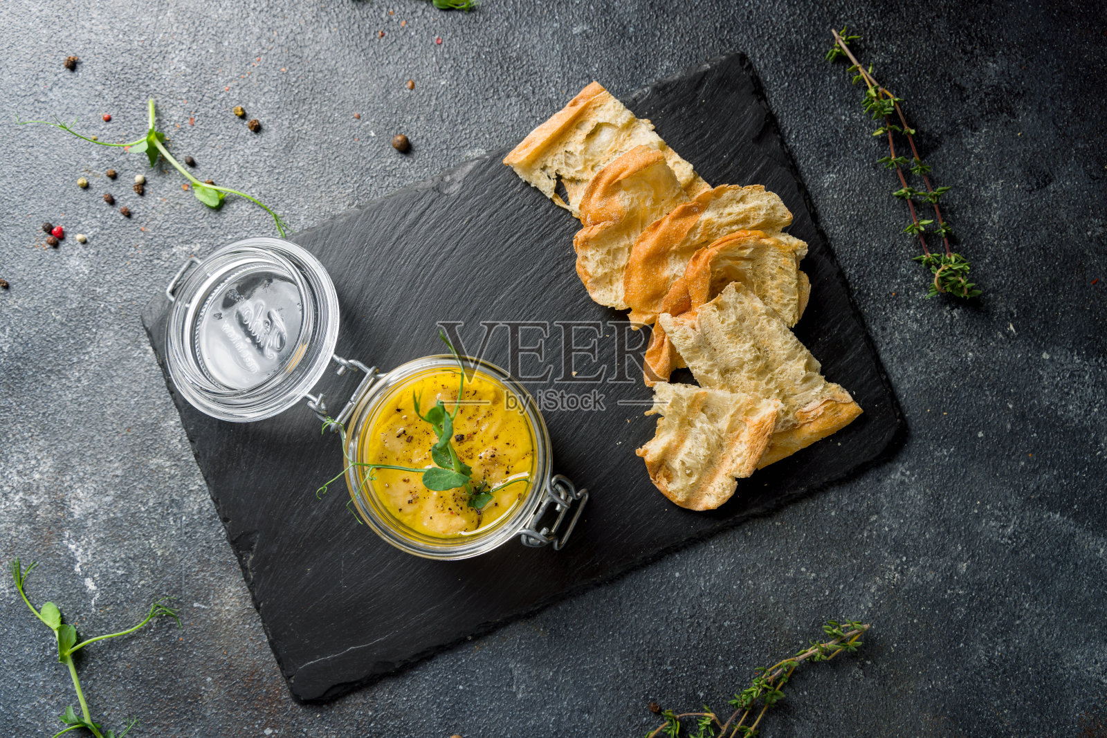 传统自制鹰嘴豆泥配面包放在黑石桌上照片摄影图片