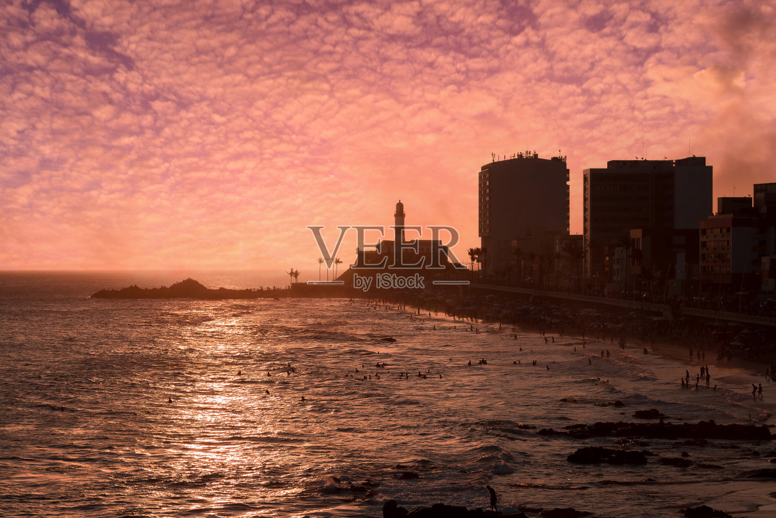 以巴拉灯塔为背景的海滩酒吧日落美景。照片摄影图片