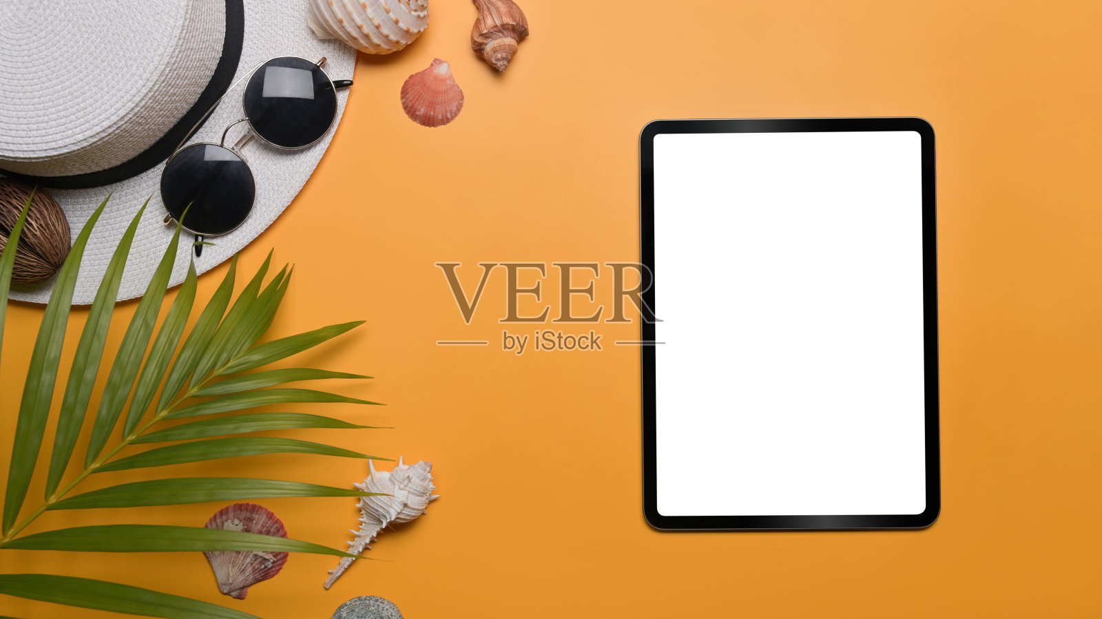 数码平板电脑，旅行配件，海贝和热带棕榈叶黄色背景。旅游，暑假和假期的概念。照片摄影图片