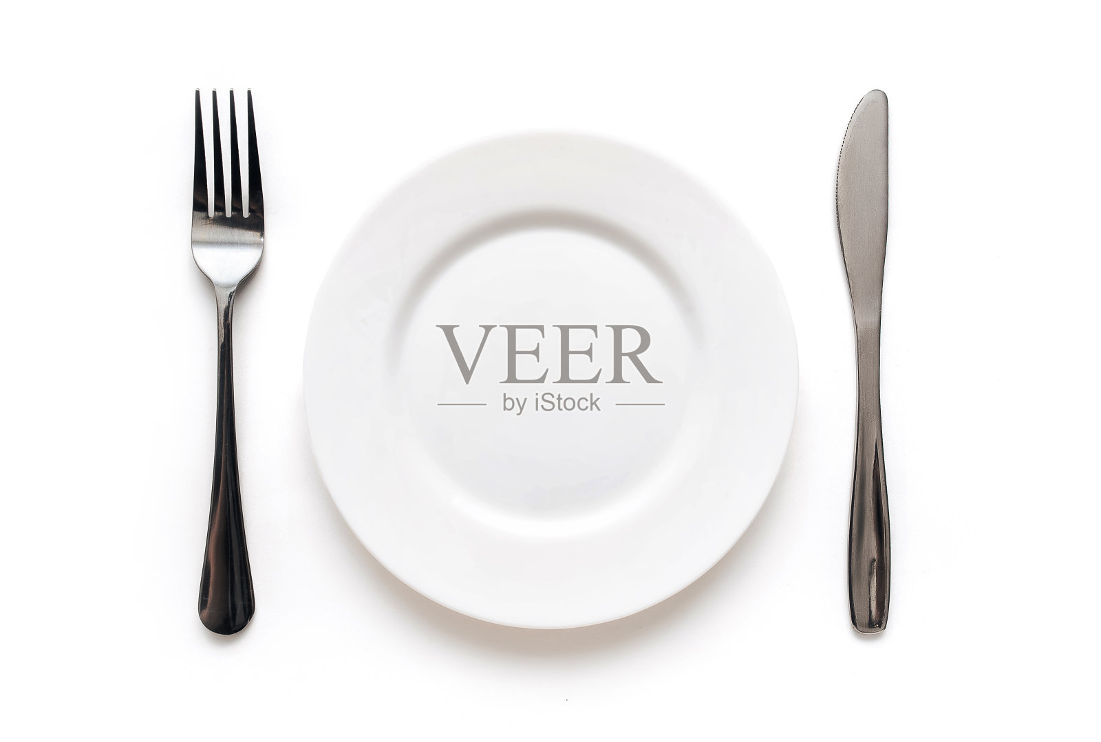 盘子，叉子和刀放在白色的桌布上。简约的概念表设置，俯视图。照片摄影图片