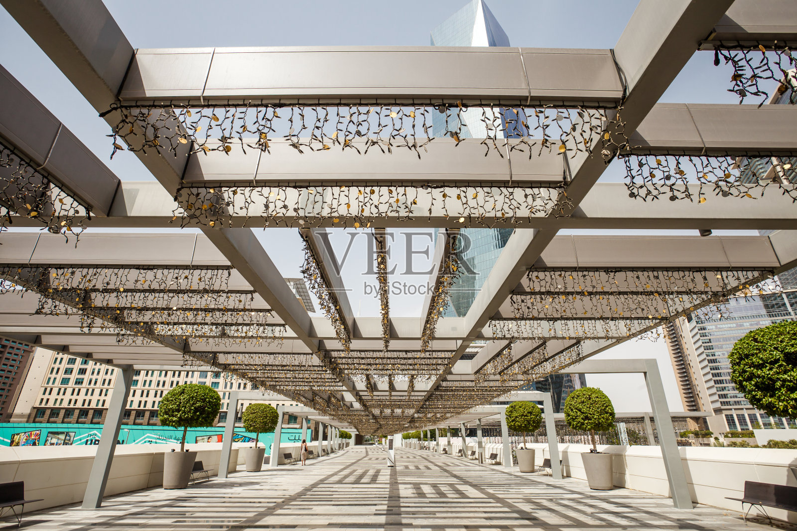 迪拜国际金融中心，阳光下的凉棚与花环照片摄影图片