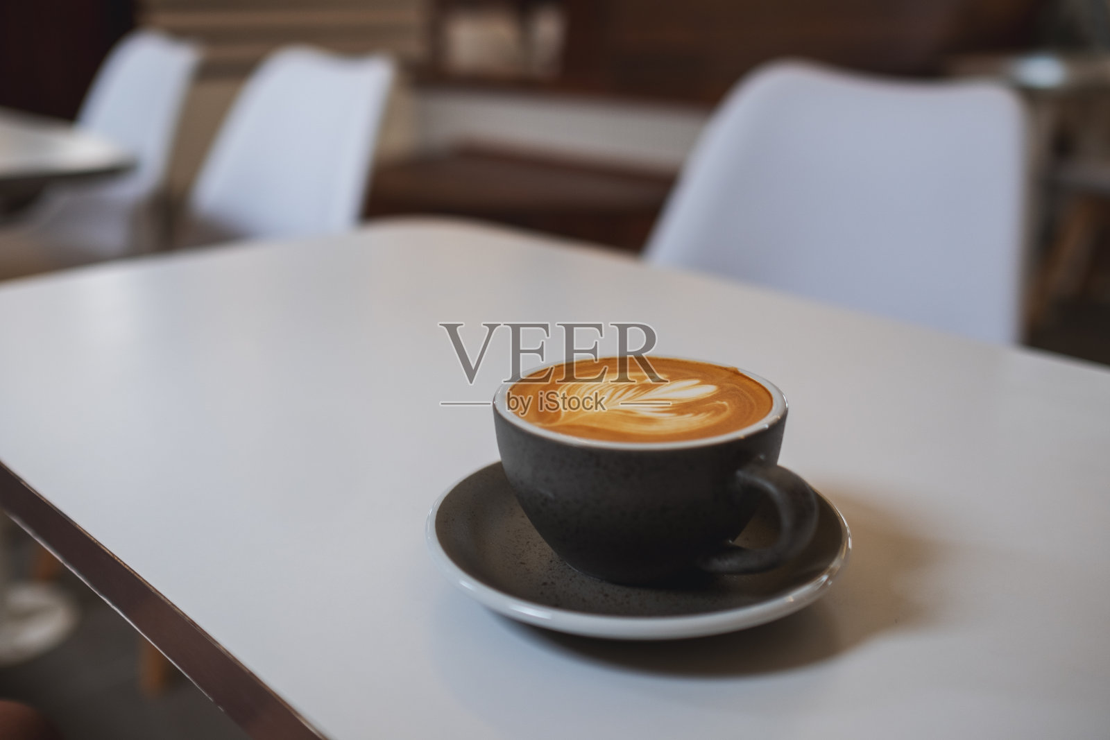咖啡桌上放着一杯热拿铁咖啡照片摄影图片