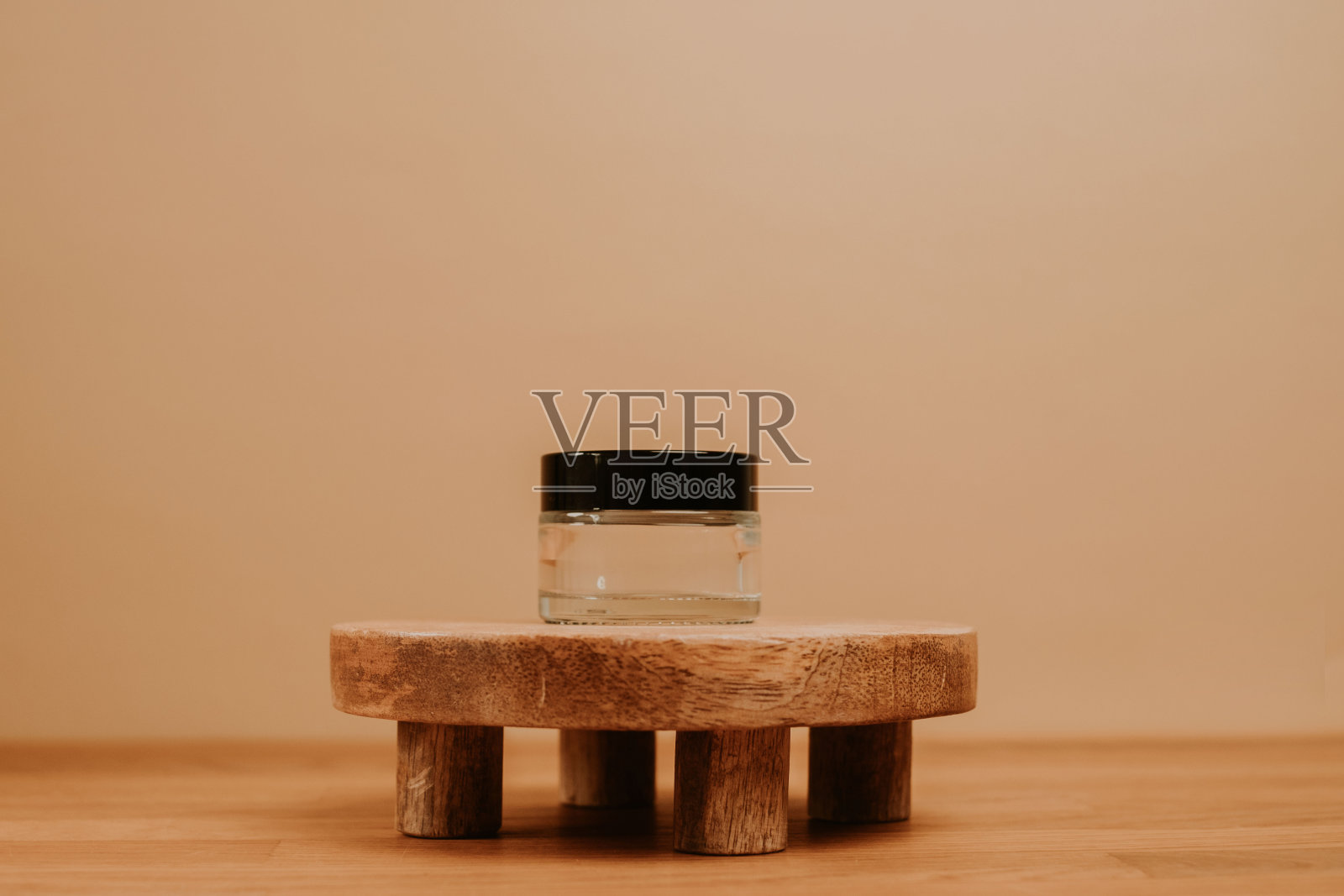 玻璃容器上的木制板和米色背景照片摄影图片