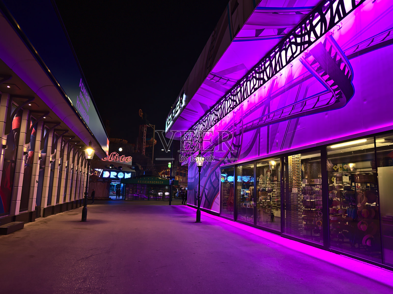 在维也纳附近的流行游乐园Wurstelprater空巷子的看法维也纳，奥地利在晚上紫色照明的建筑。照片摄影图片