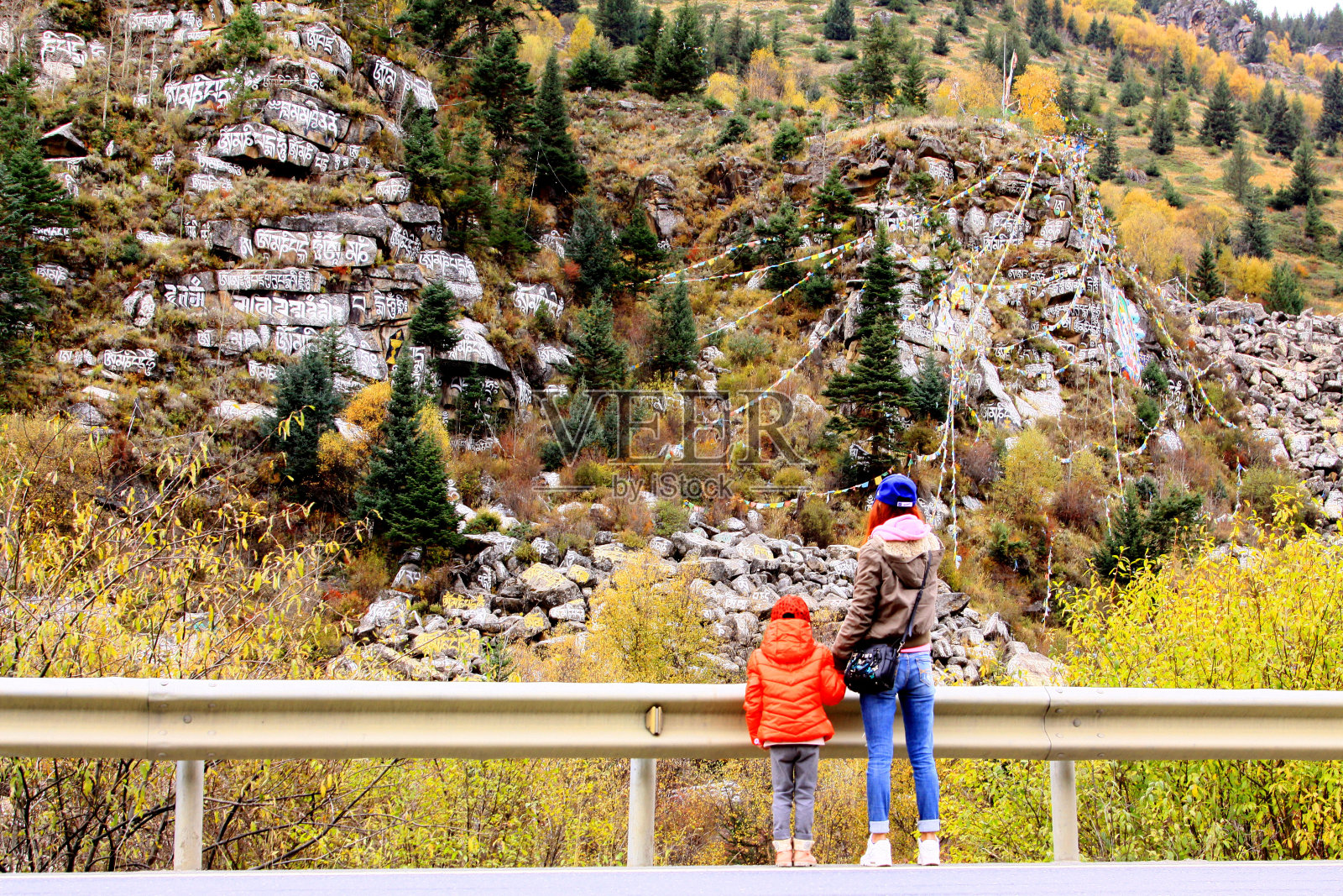 Manidui (Marnyi石头。石刻经书)和经幡在路旁的新都桥到大公照片摄影图片