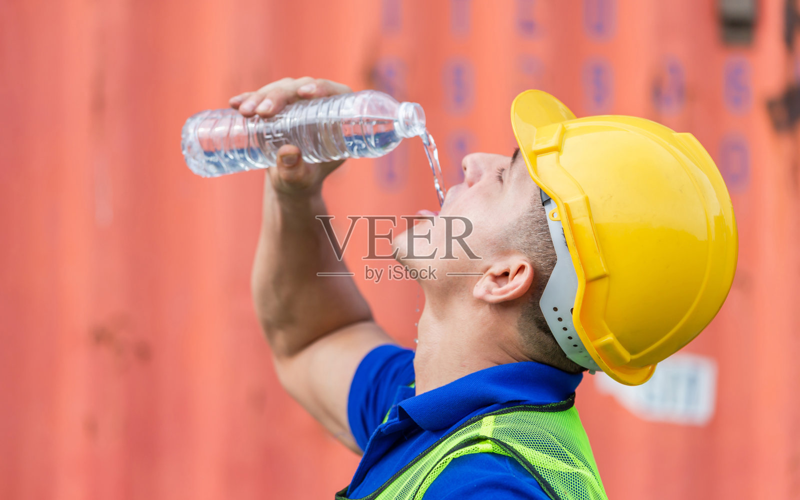 码头工人戴着安全帽在集装箱货场喝水照片摄影图片