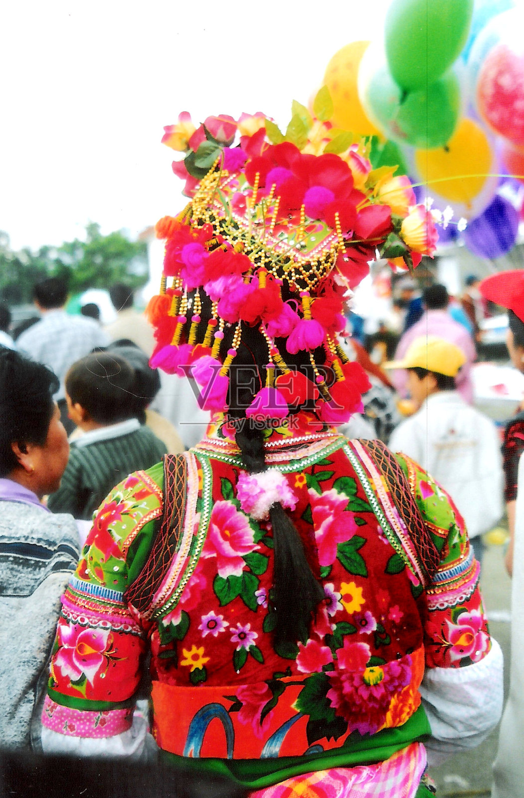 1999年，大理三月界集市上，彝族妇女在节日中穿着五颜六色的服饰和头饰照片摄影图片