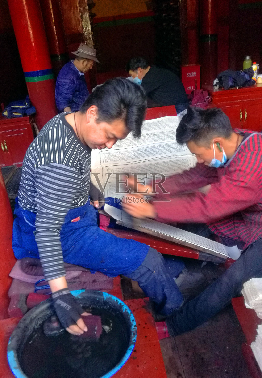 房屋内部，工匠们手工印刷各种经文照片摄影图片