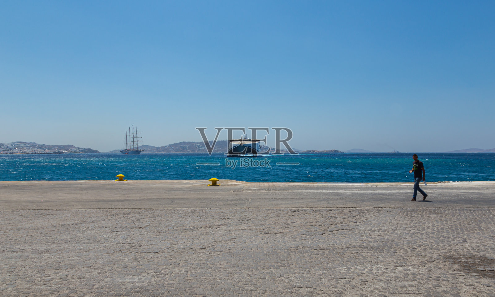 一艘大型双体船抵达米科诺斯港。基克拉底群岛爱琴海基克拉底群岛中的一个岛屿水溅在码头上照片摄影图片