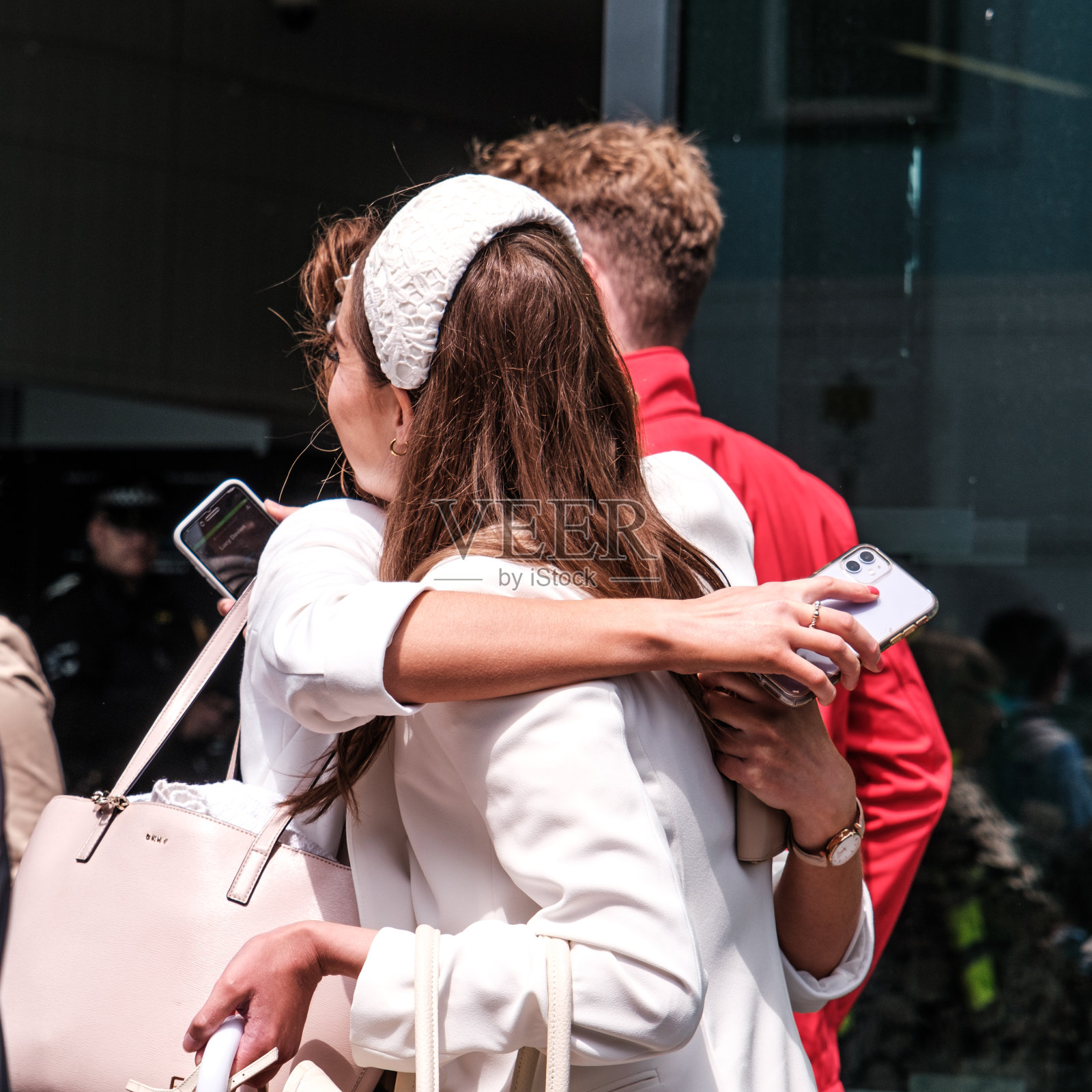 两个深情的年轻女子见面并抱着手机照片摄影图片