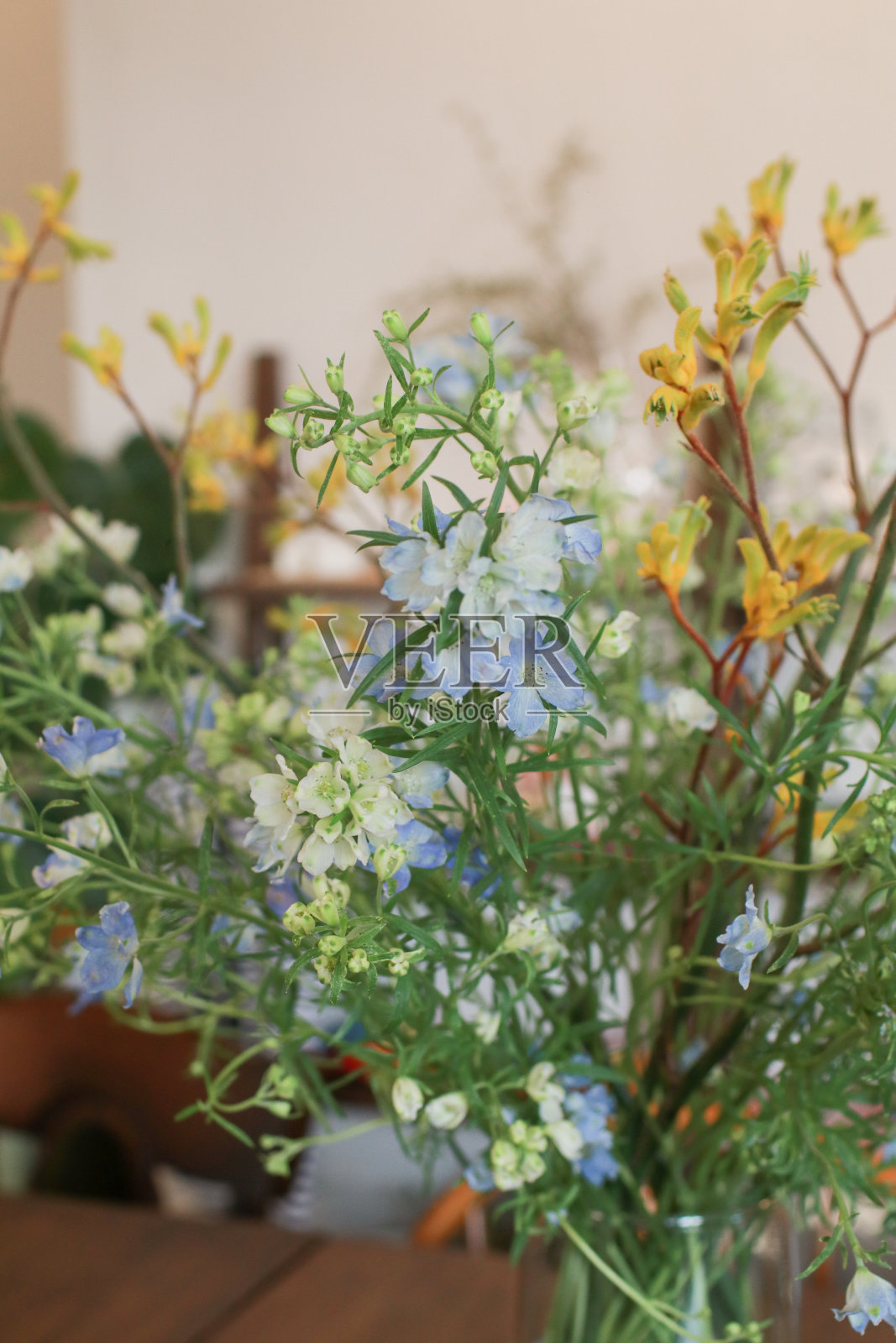 花瓶里放着一束美丽的夏季黄色野花。春天的背景。桌上的小玻璃花瓶里插着野花。照片摄影图片
