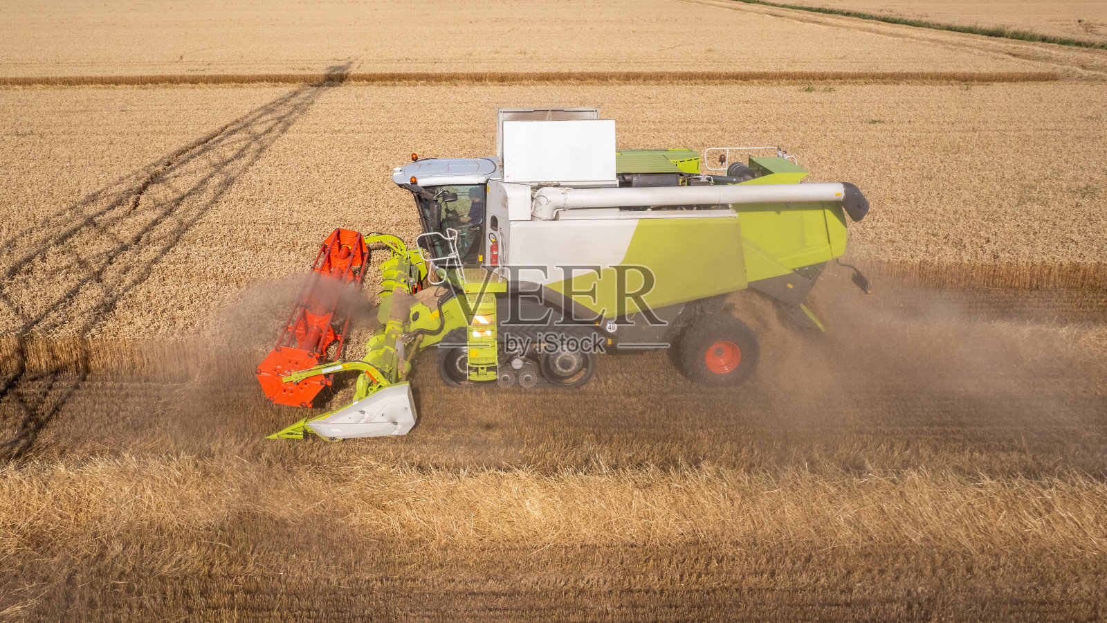 农家金田炎热季节收割机收割小麦的航拍照片照片摄影图片
