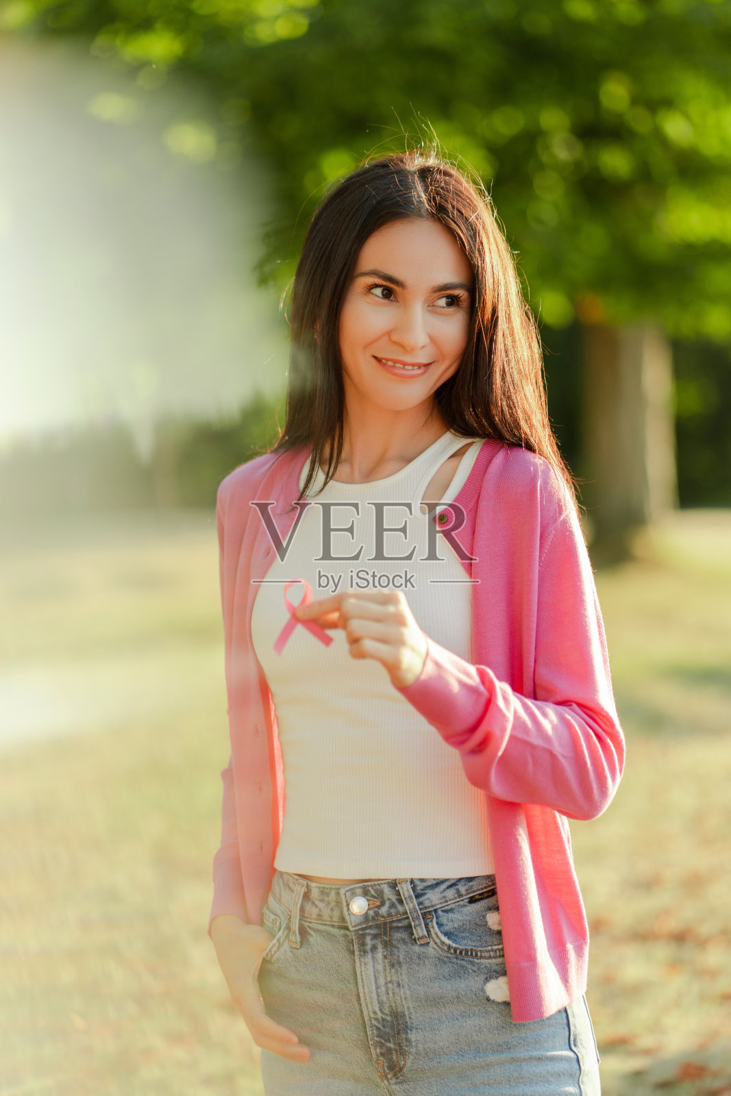 美丽的微笑的女人在街上摆着粉红色的丝带的肖像照片摄影图片