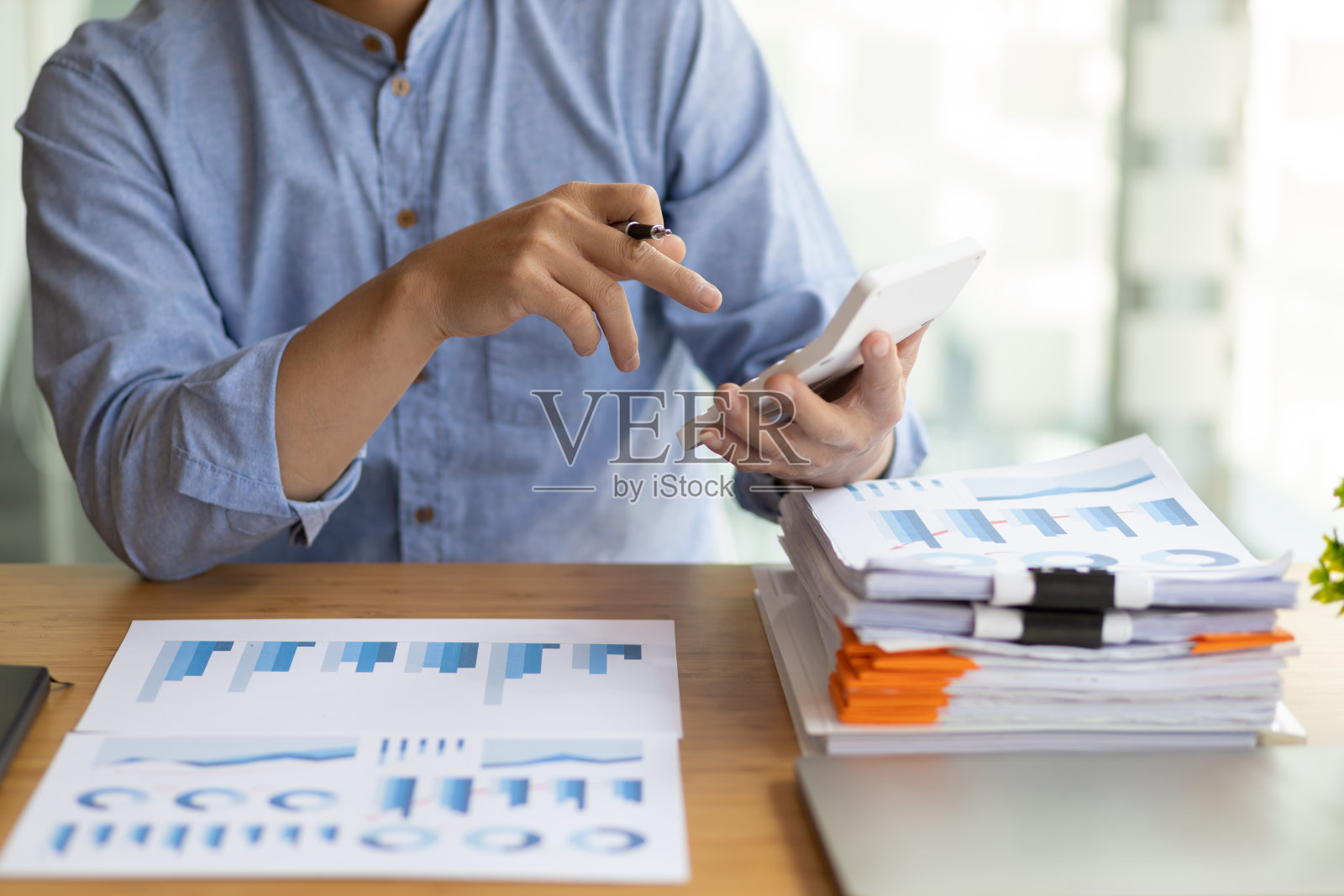 商务人士在办公桌上处理商务报告，用计算器分析财务图表，制定会计财务报表。照片摄影图片