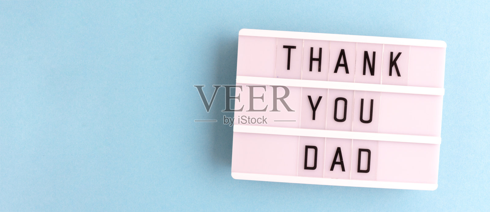 谢谢你，爸爸。白色灯箱，蓝色背景上有字母。照片摄影图片