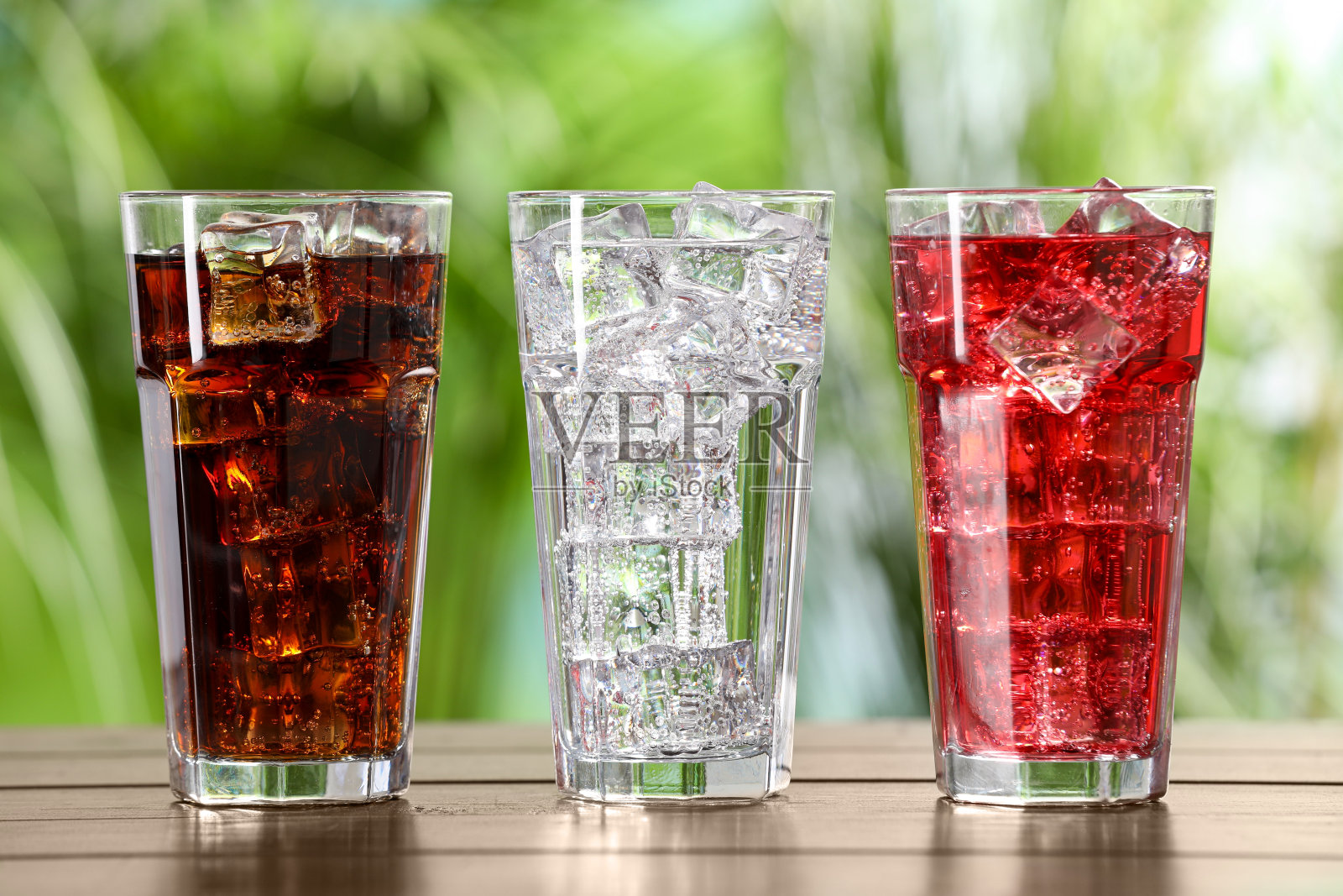 在户外的木桌上放着不同口味的苏打水和冰块照片摄影图片