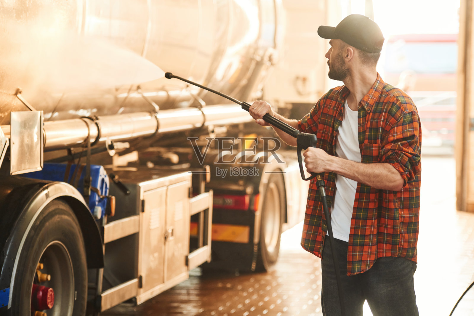 洗车。穿着便服的年轻卡车司机照片摄影图片