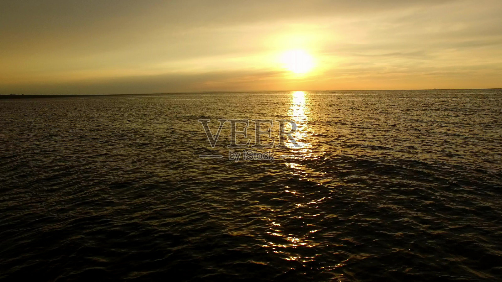 日落时低空在海水上飞行照片摄影图片
