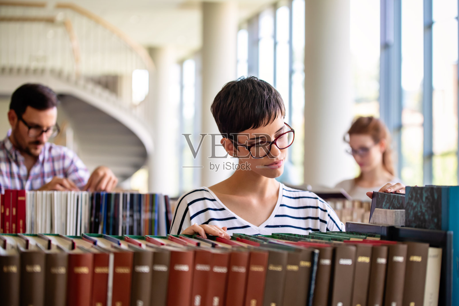 在图书馆学习的学生。年轻的成功人士花时间在一起，一起学习。照片摄影图片